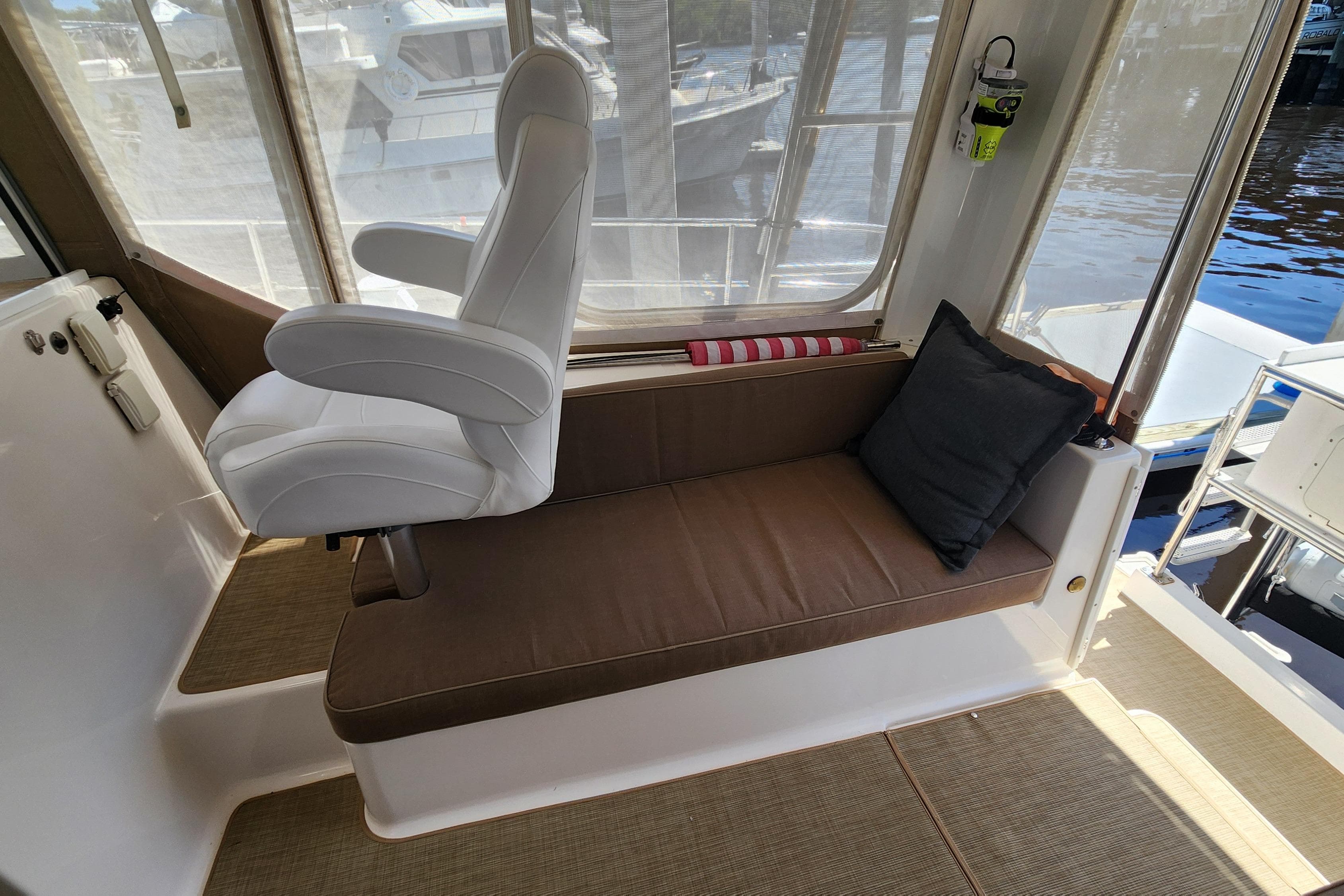 Interior of 2003 Endeavour 44 TrawlerCat with cushioned seating and helm chair.