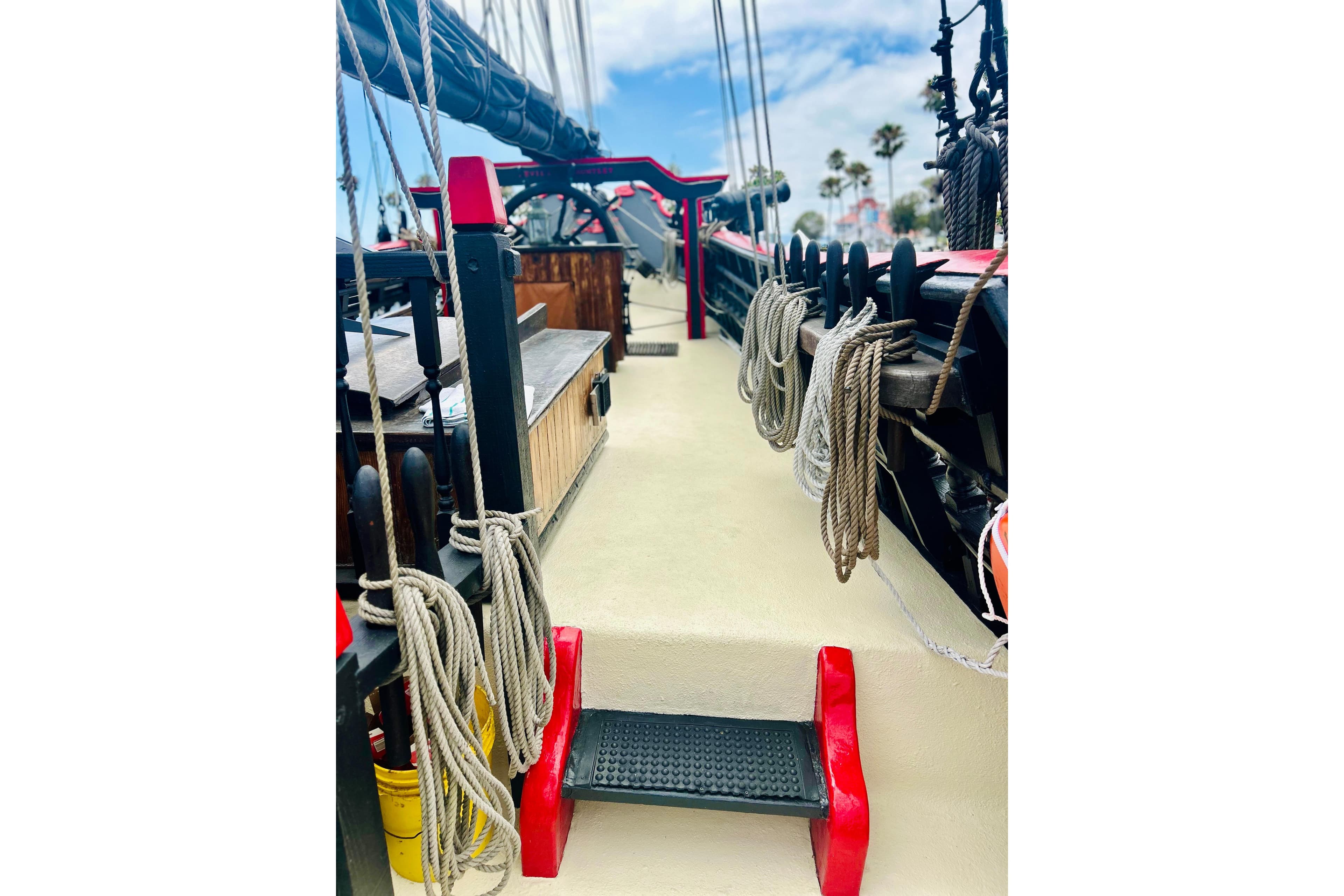 Deck view of a 1977 Custom Brigantine ship with ropes and red accents.