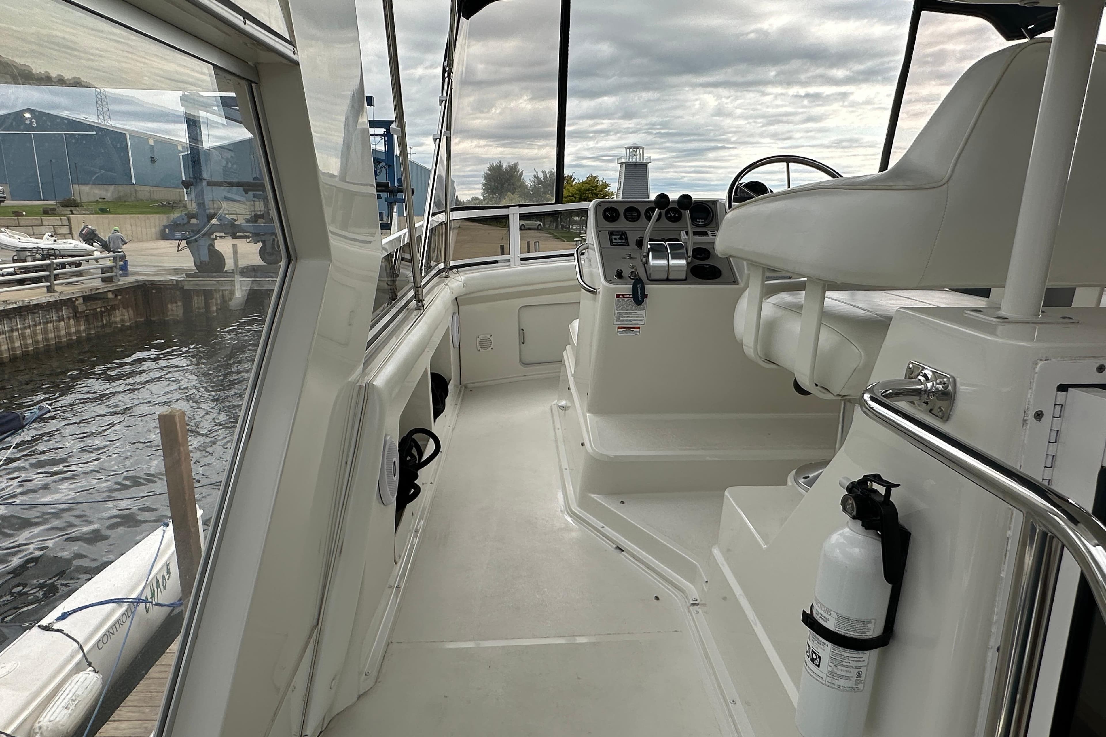 1998 Carver 445 Aft Cabin Motor Yacht helm with steering wheel and controls, dockside view.