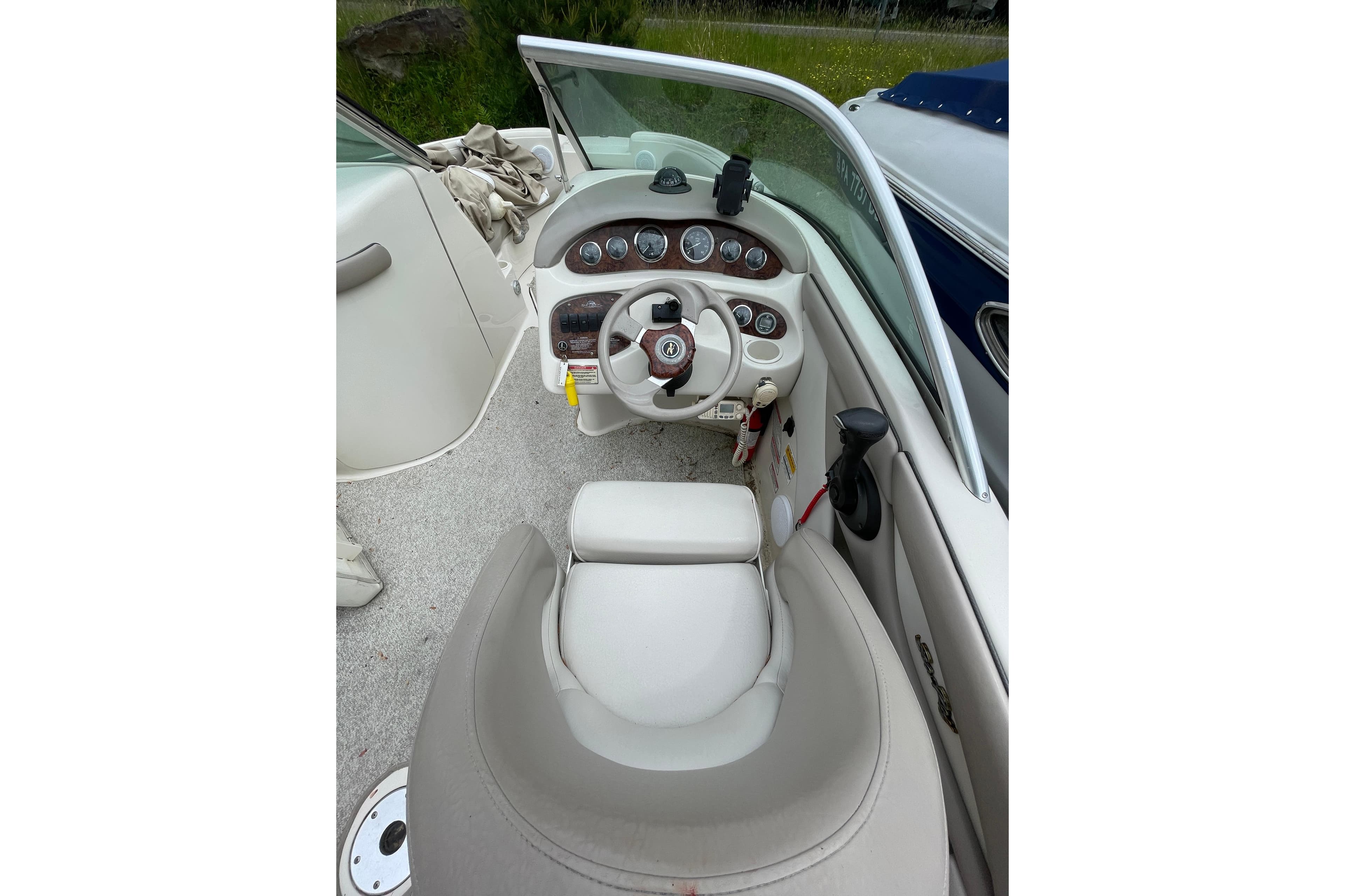 Interior view of a 2002 Sea Ray 210 Sundeck boat cockpit with steering wheel and gauges.