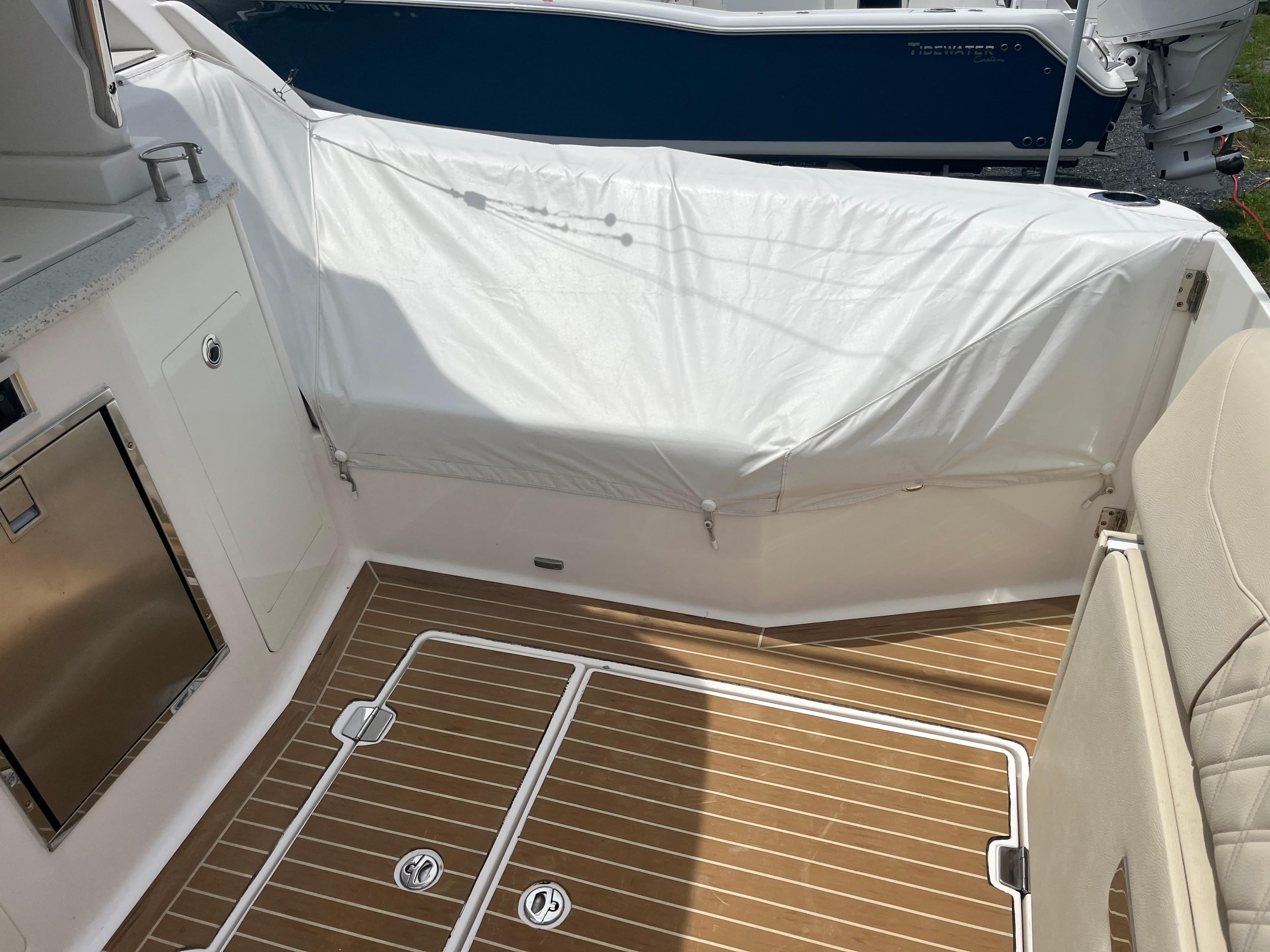 2019 Regal 33 SAV boat interior with teak flooring and covered seating area.