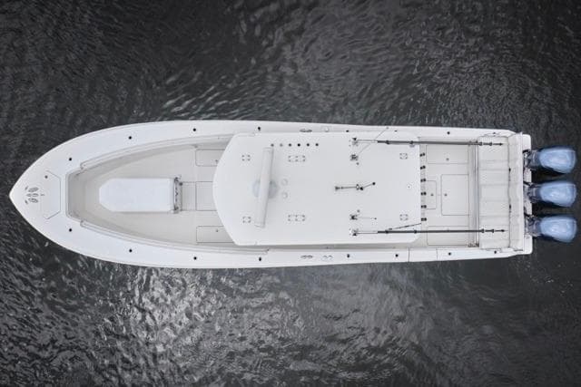 Aerial view of 2015 Invincible 36 boat with triple engines on water.