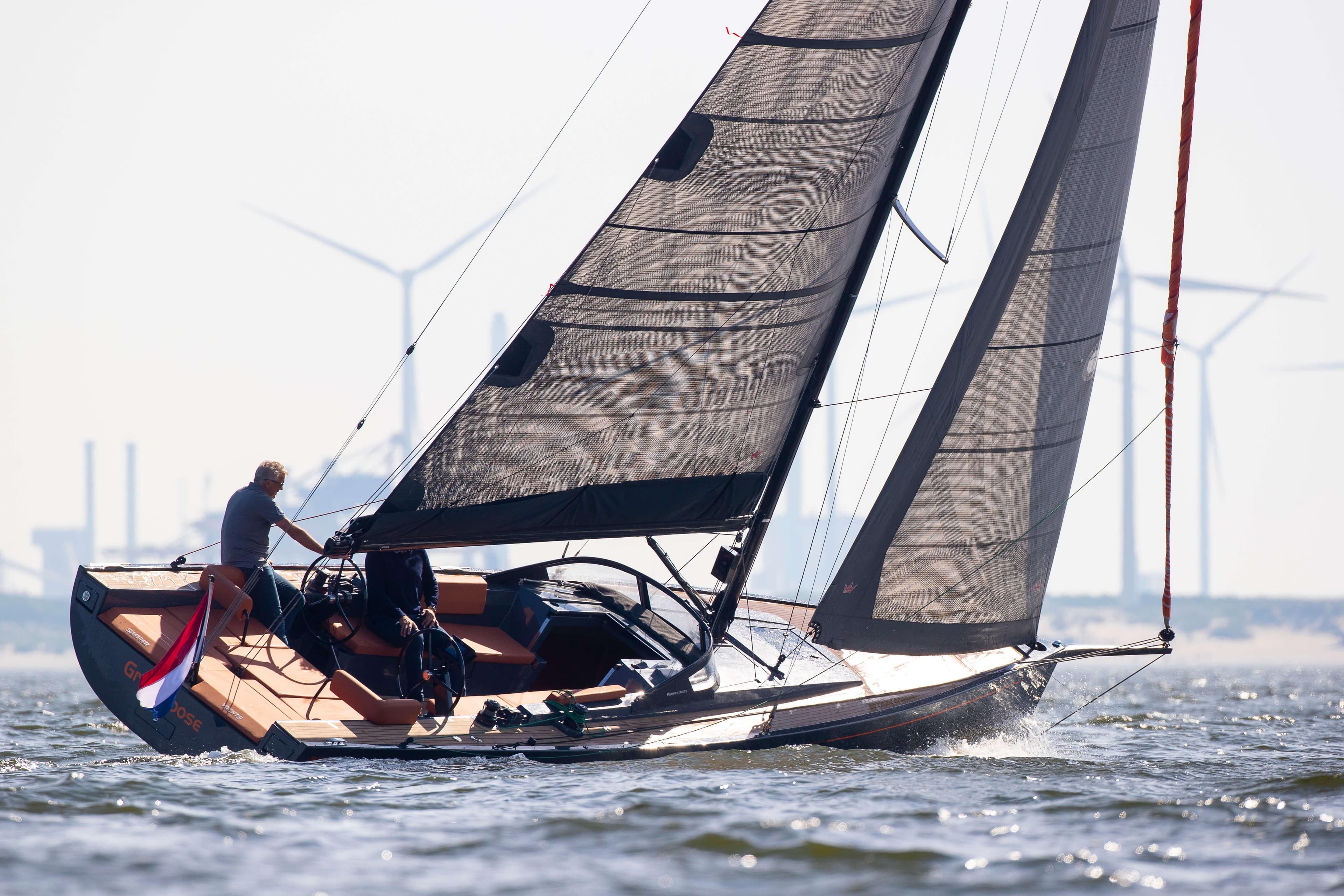 Saffier SE 33 Life 2026 sailing yacht on water with wind turbines in background.