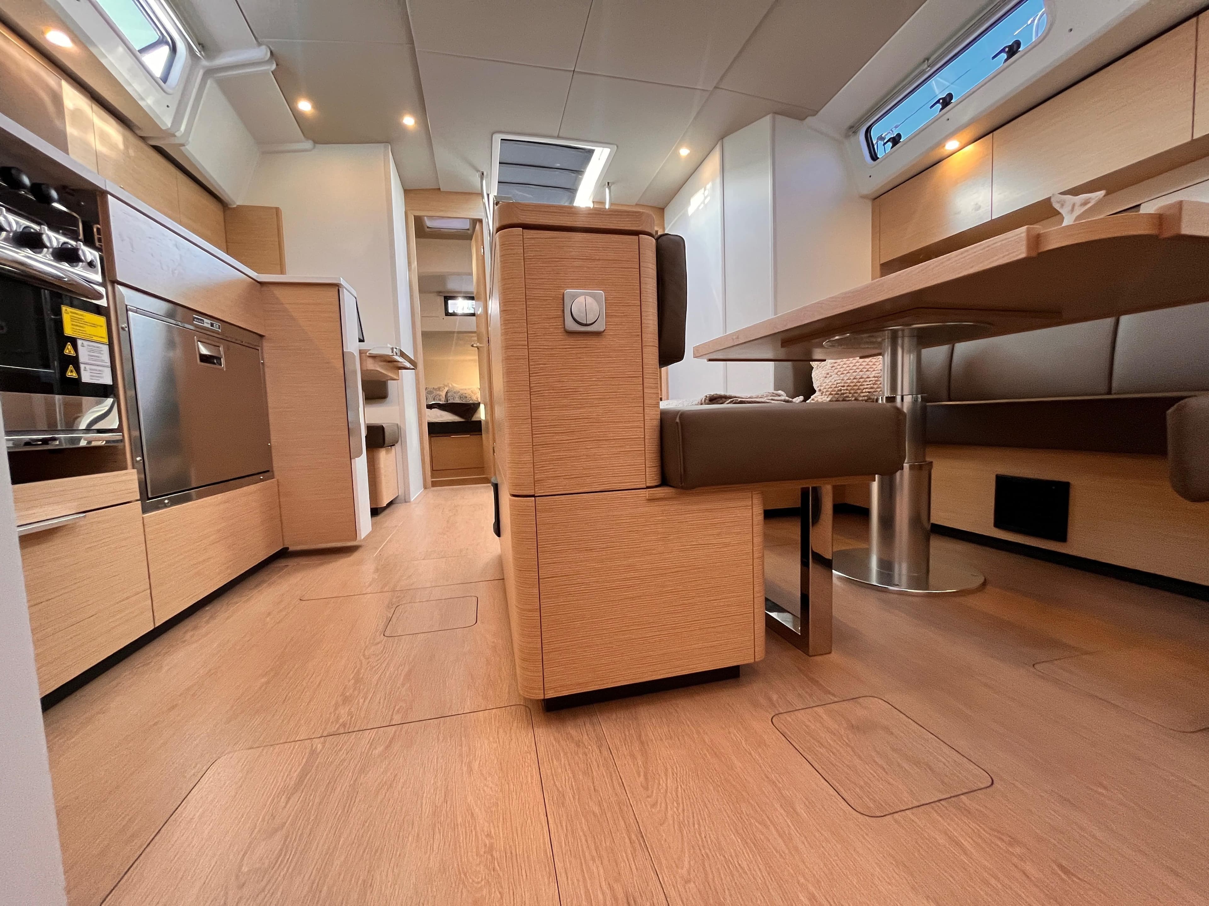 Modern interior of 2023 Hanse 460 yacht with sleek kitchen and dining area.
