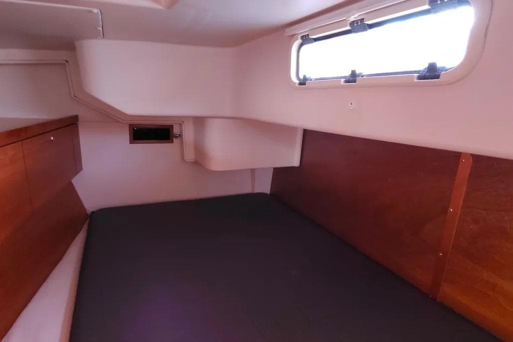 Interior cabin of 2007 Hanse 470e yacht with wooden paneling and window.
