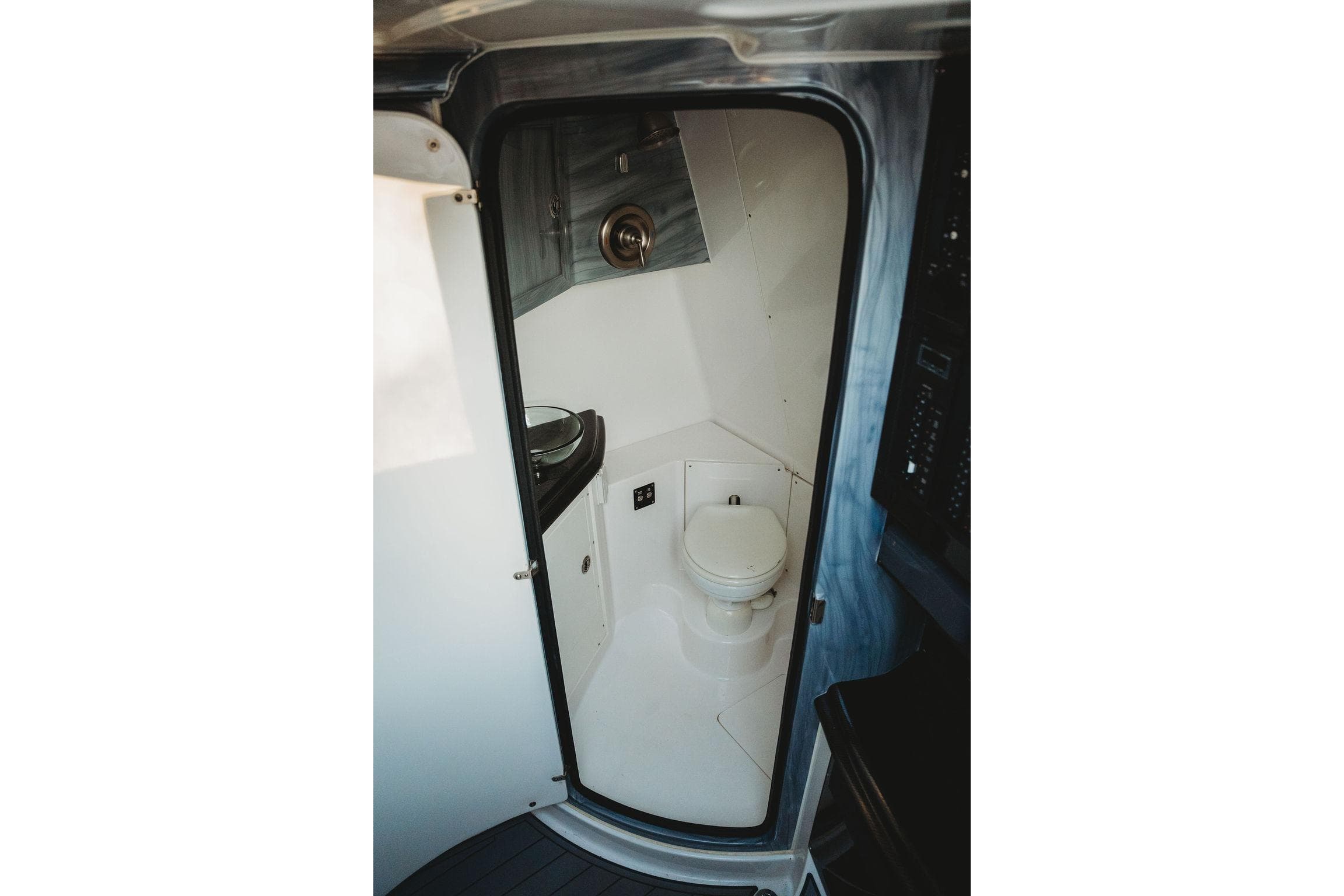 Compact bathroom inside 2018 MTI 57 boat, featuring a toilet and sink.
