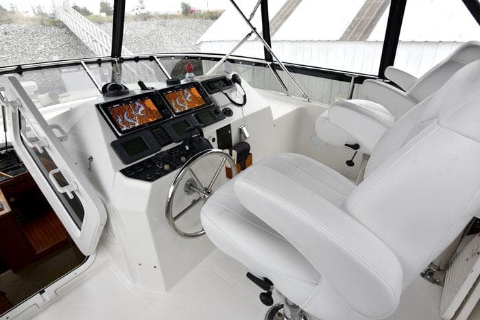 Pilothouse of 2001 Symbol Raised Pilothouse Motoryacht with navigation screens and white seating.