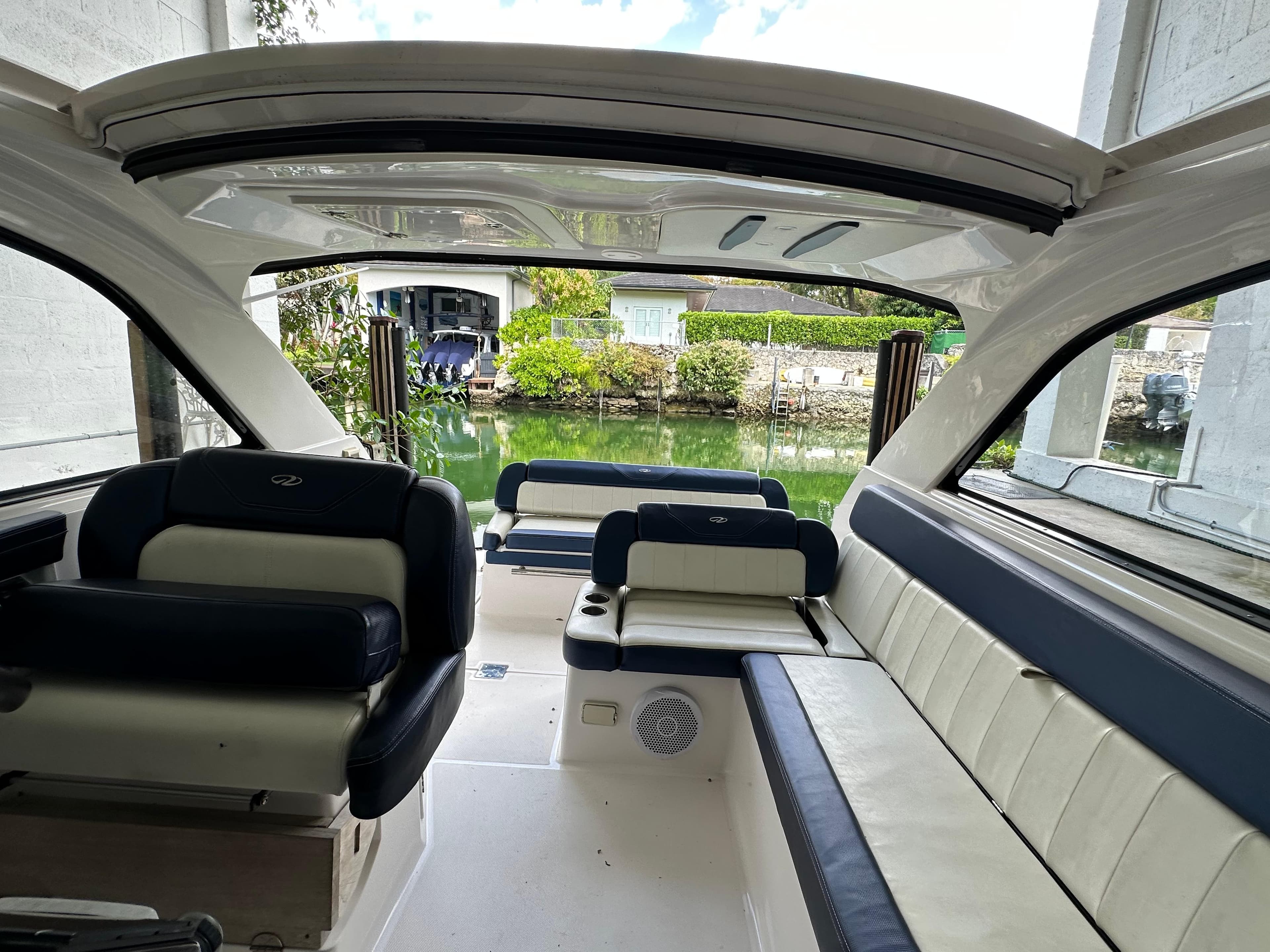 2014 Regal 35 Sport Coupe interior with spacious seating and open sunroof, docked by a serene canal.