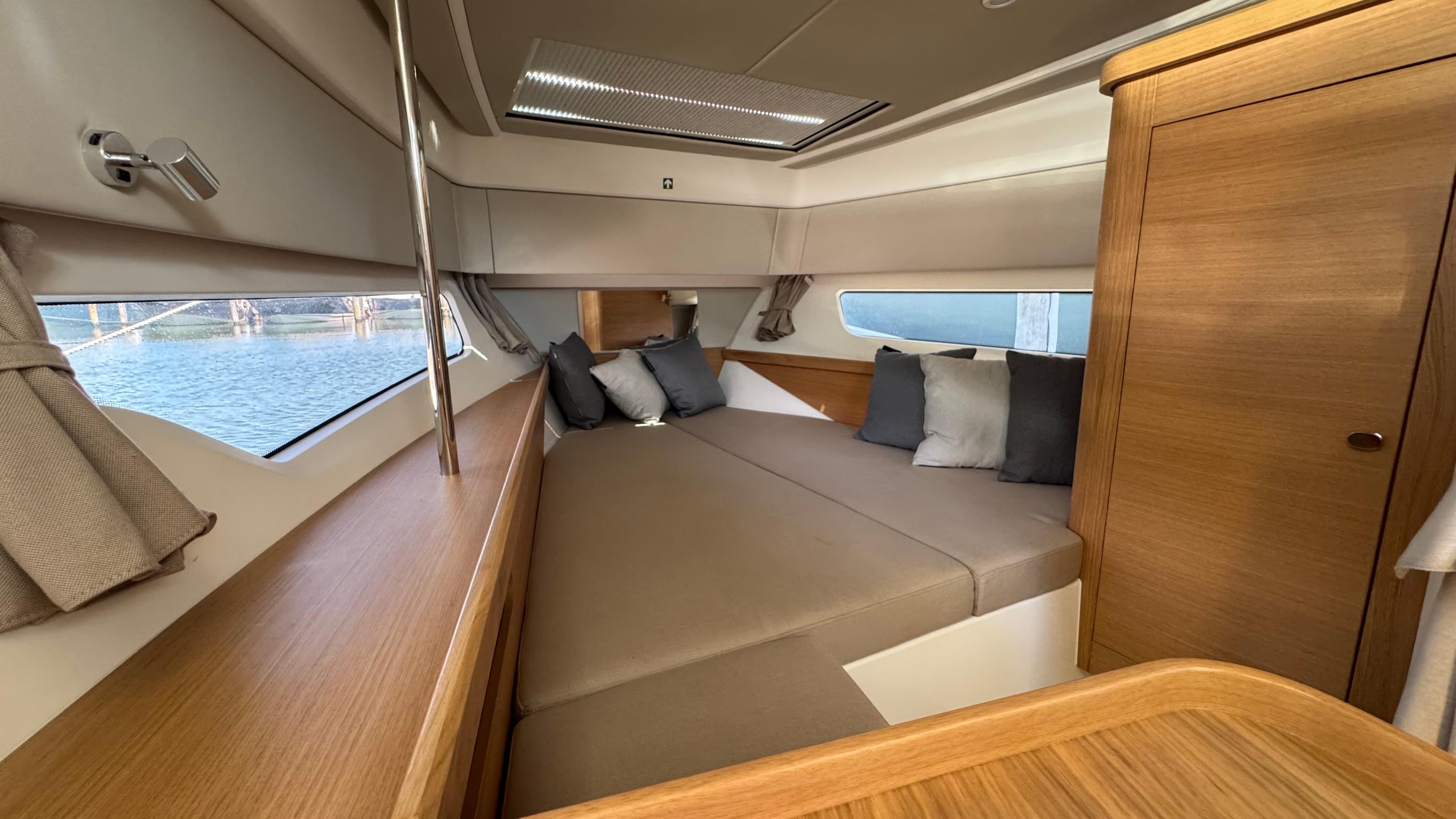 Luxurious interior cabin of 2024 Nimbus W11 yacht with cozy bedding and wooden finishes.