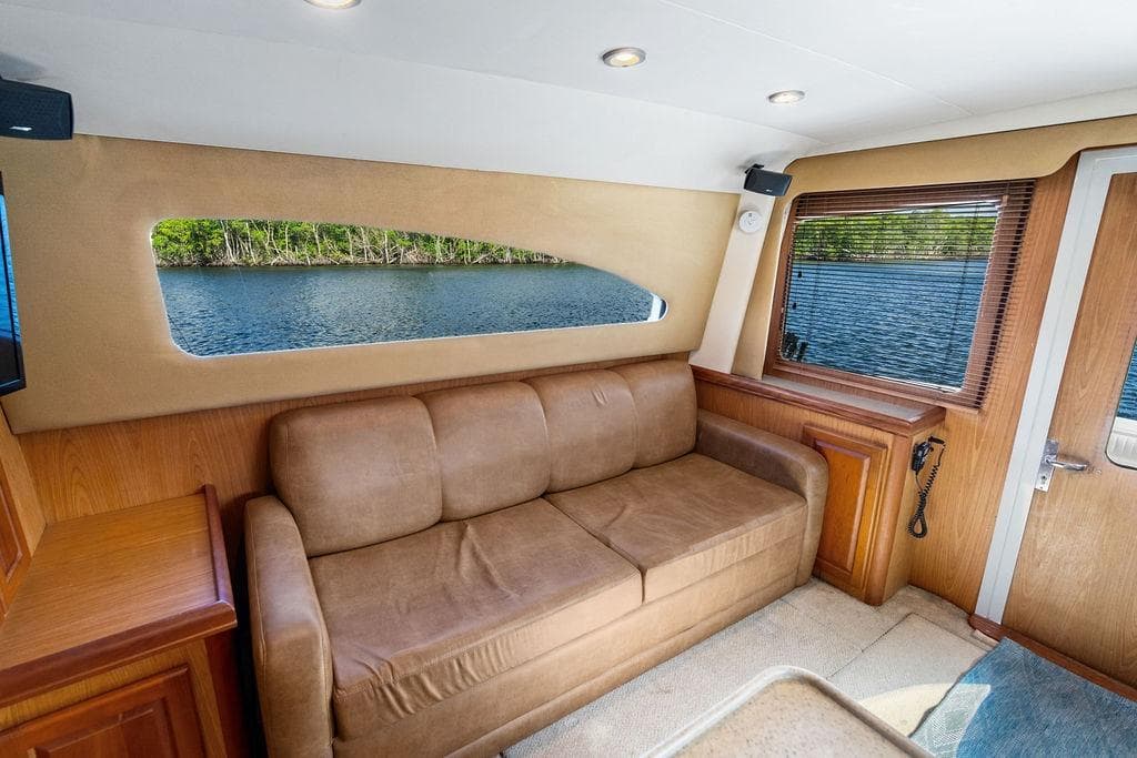 Interior of 2005 Luhrs 38 Convertible yacht with brown sofa and scenic water view.
