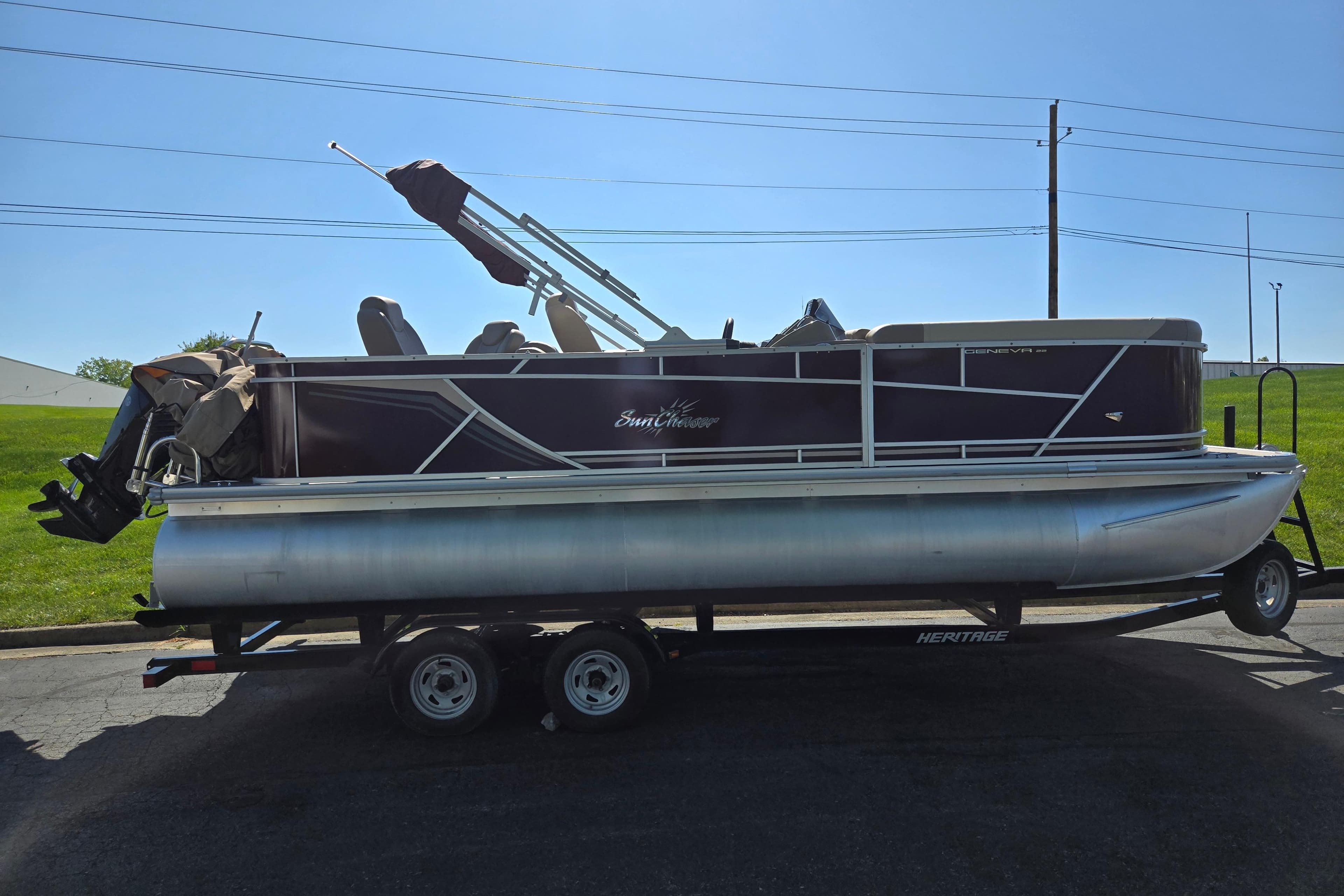 2023 SunChaser Geneva Fish 22 pontoon boat on trailer, side view.