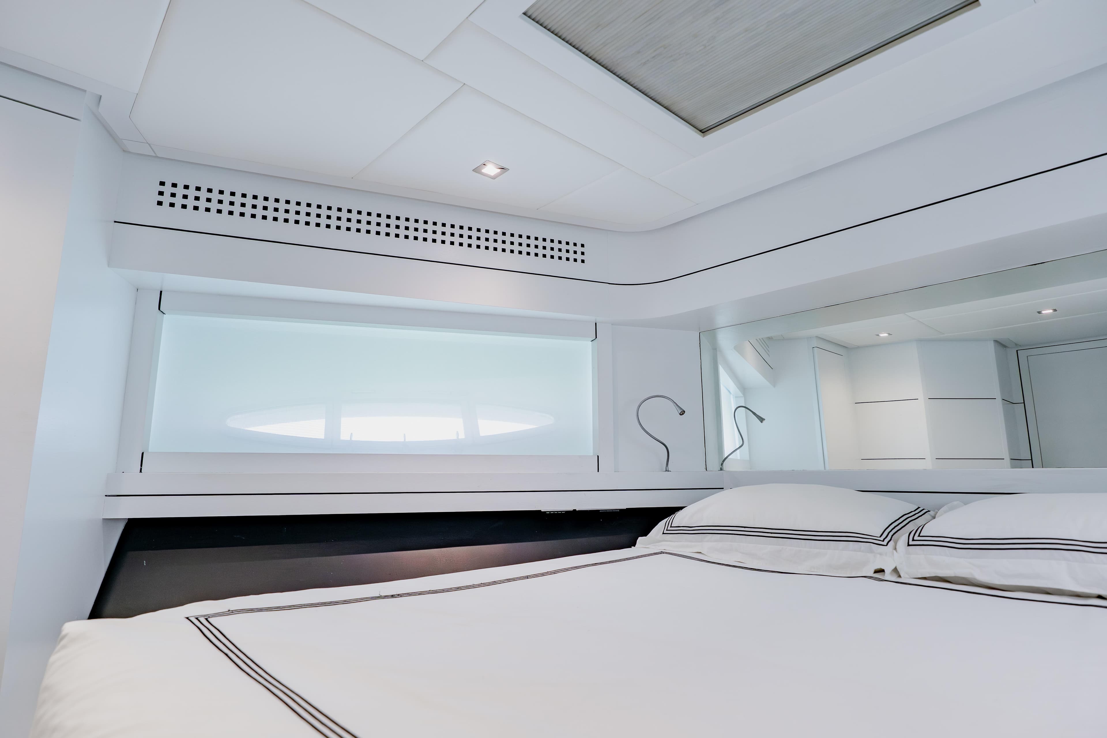 Luxurious bedroom interior of 2010 Pershing 80 yacht with modern design and elegant bedding.