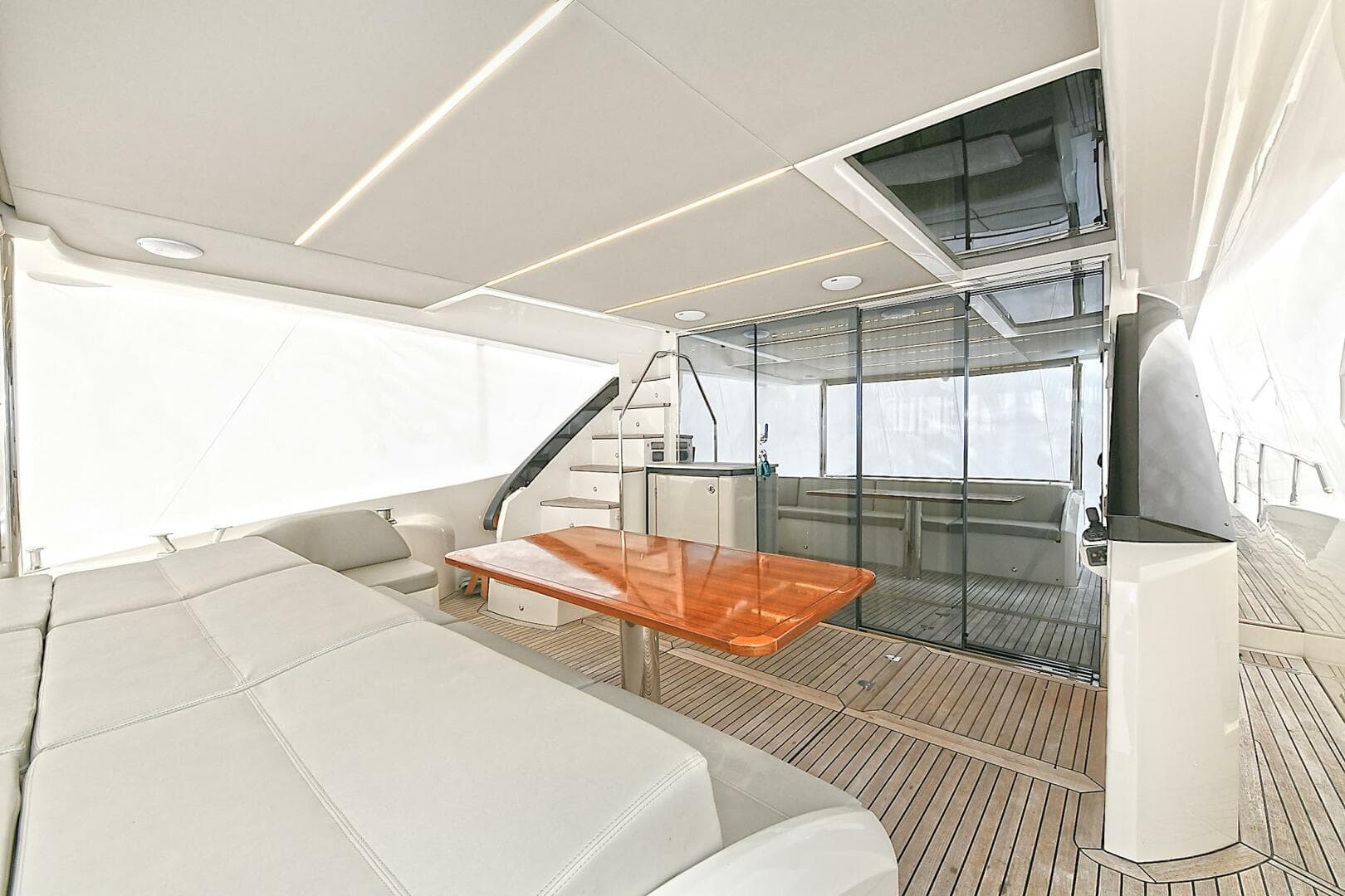 Luxurious interior of 2022 Absolute 62 Fly yacht with modern seating and wooden table.