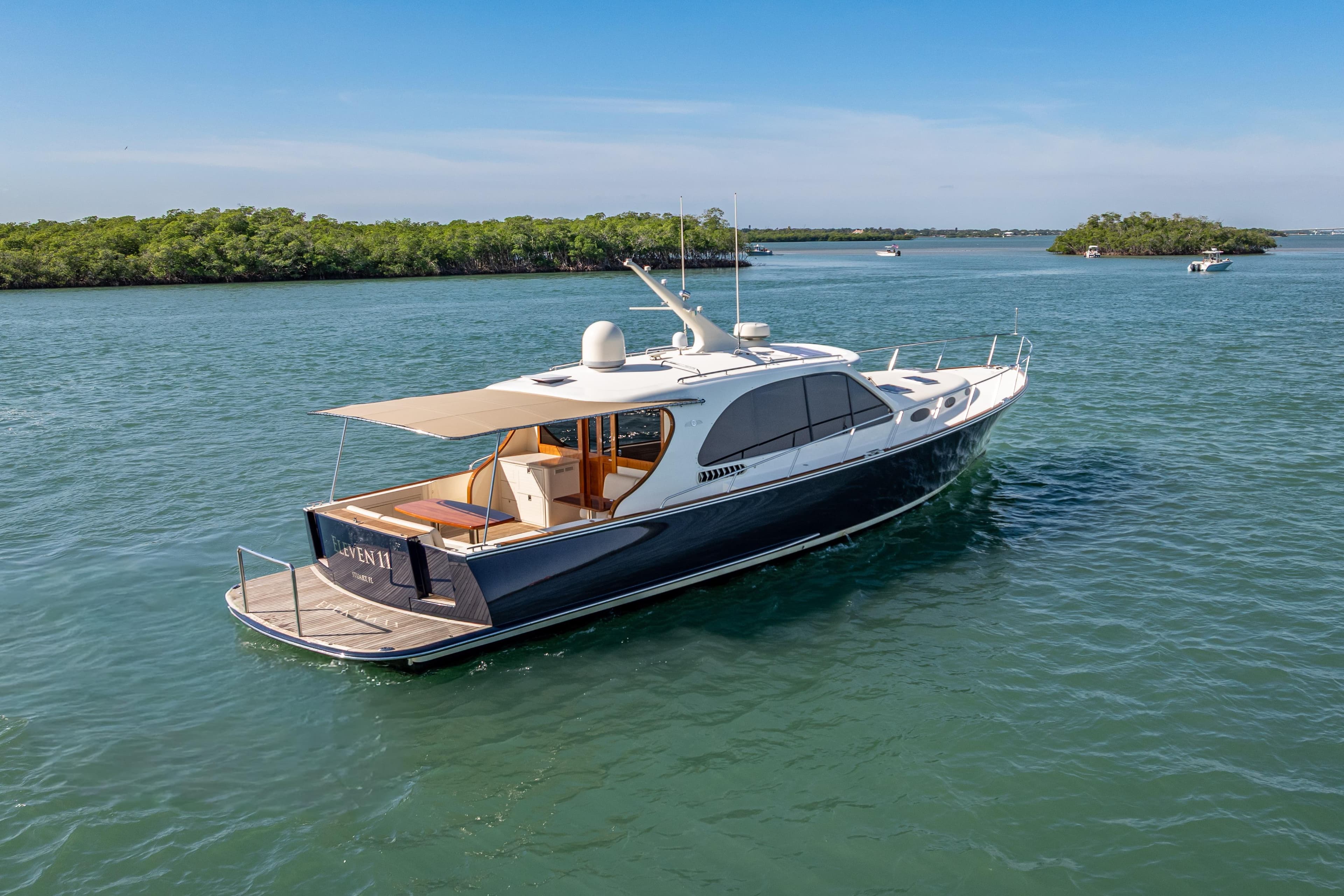 2018 Palm Beach Motor Yachts PB55 cruising on serene waters, surrounded by lush greenery.