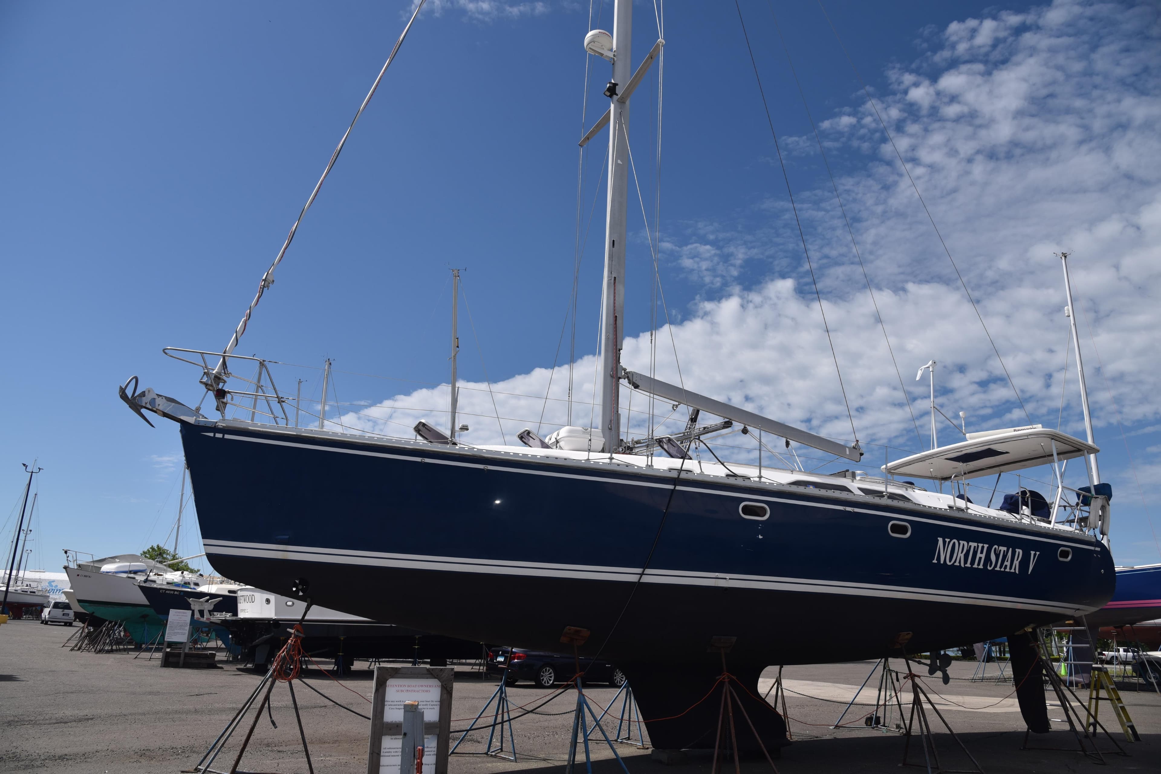 Catalina 470 sailboat from 2002 on dry dock under a clear blue sky.