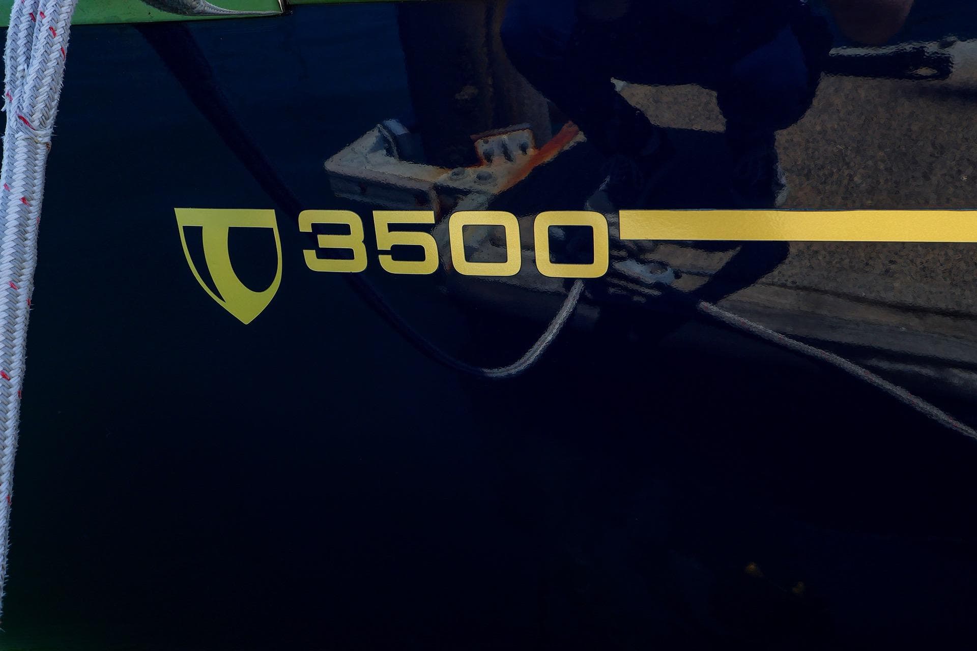 Tartan 3500 sailboat logo on dark hull, featuring yellow text and emblem.