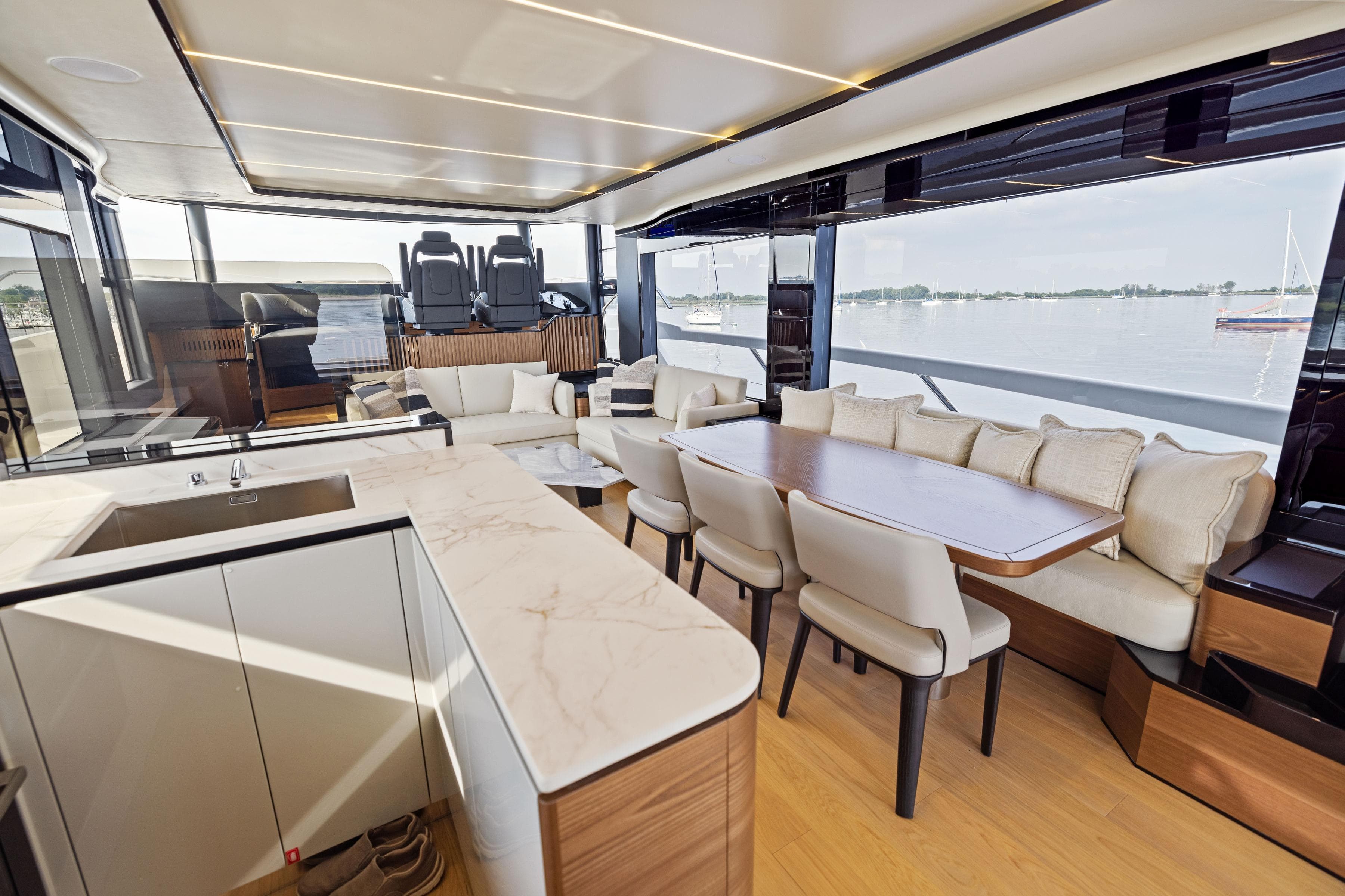 Luxurious interior of 2024 Absolute Navetta 64 yacht with elegant dining and seating area.