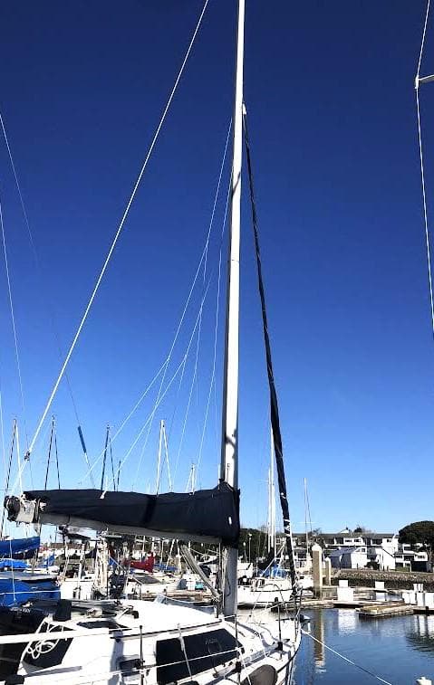 Sailboat Hunter Vision 32, 1990 model, docked under clear blue sky.