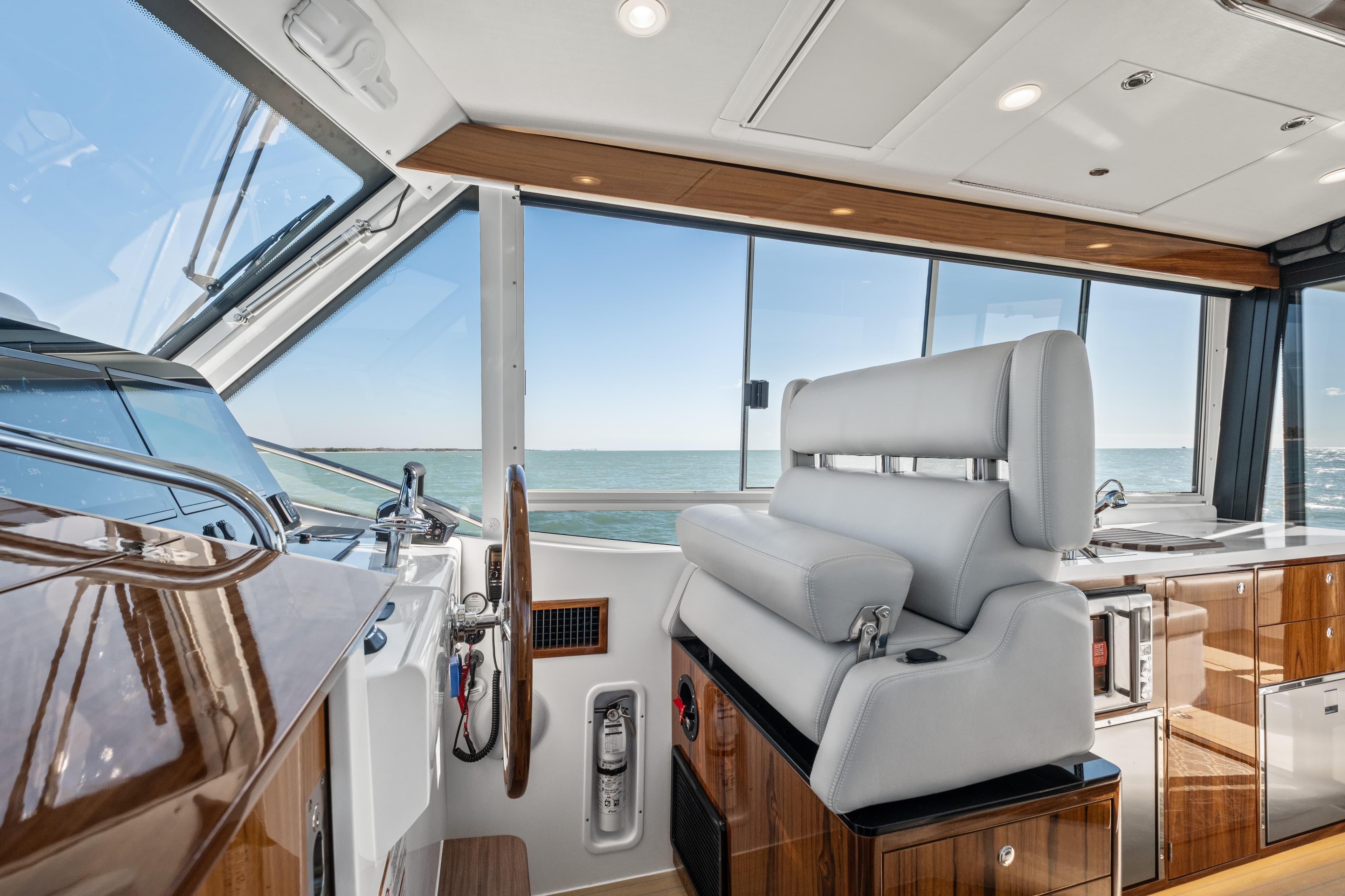 Luxurious interior of 2026 MJM 47 R yacht with ocean view and modern helm station.