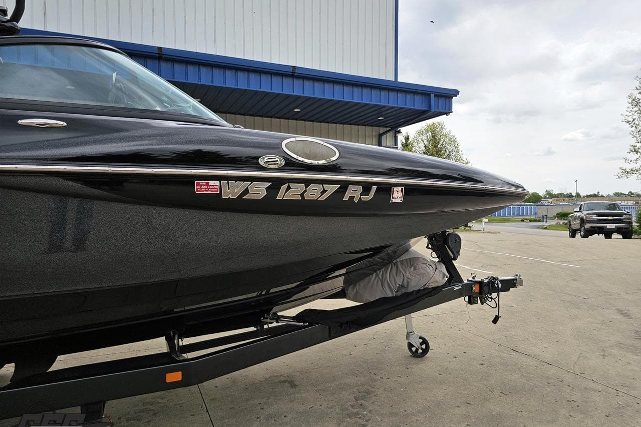 2018 Supreme S226 boat on trailer outside a blue-roofed building.