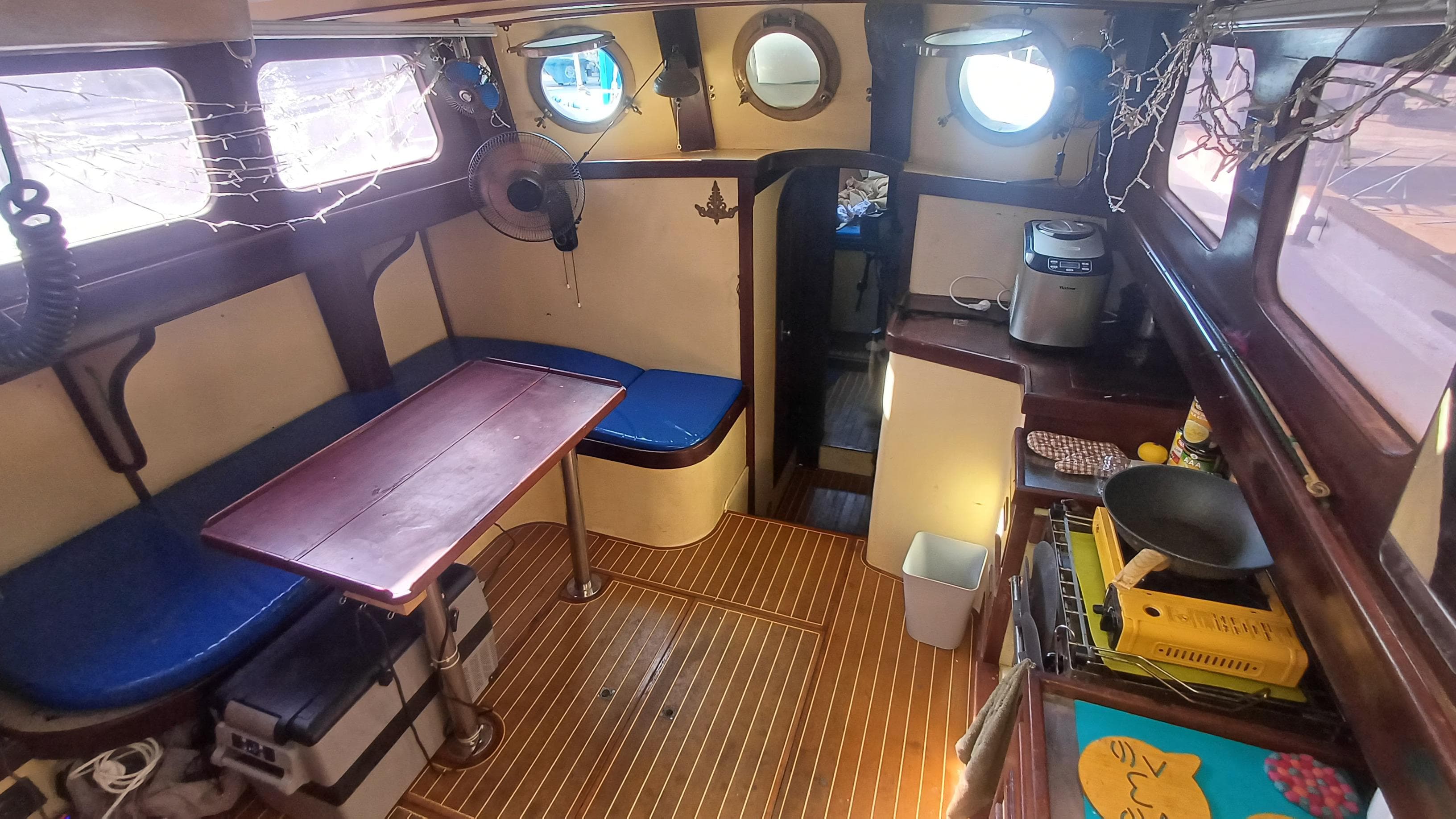 Interior of 1982 Sino American Yacht Landfall 39, featuring cozy seating and compact kitchen area.