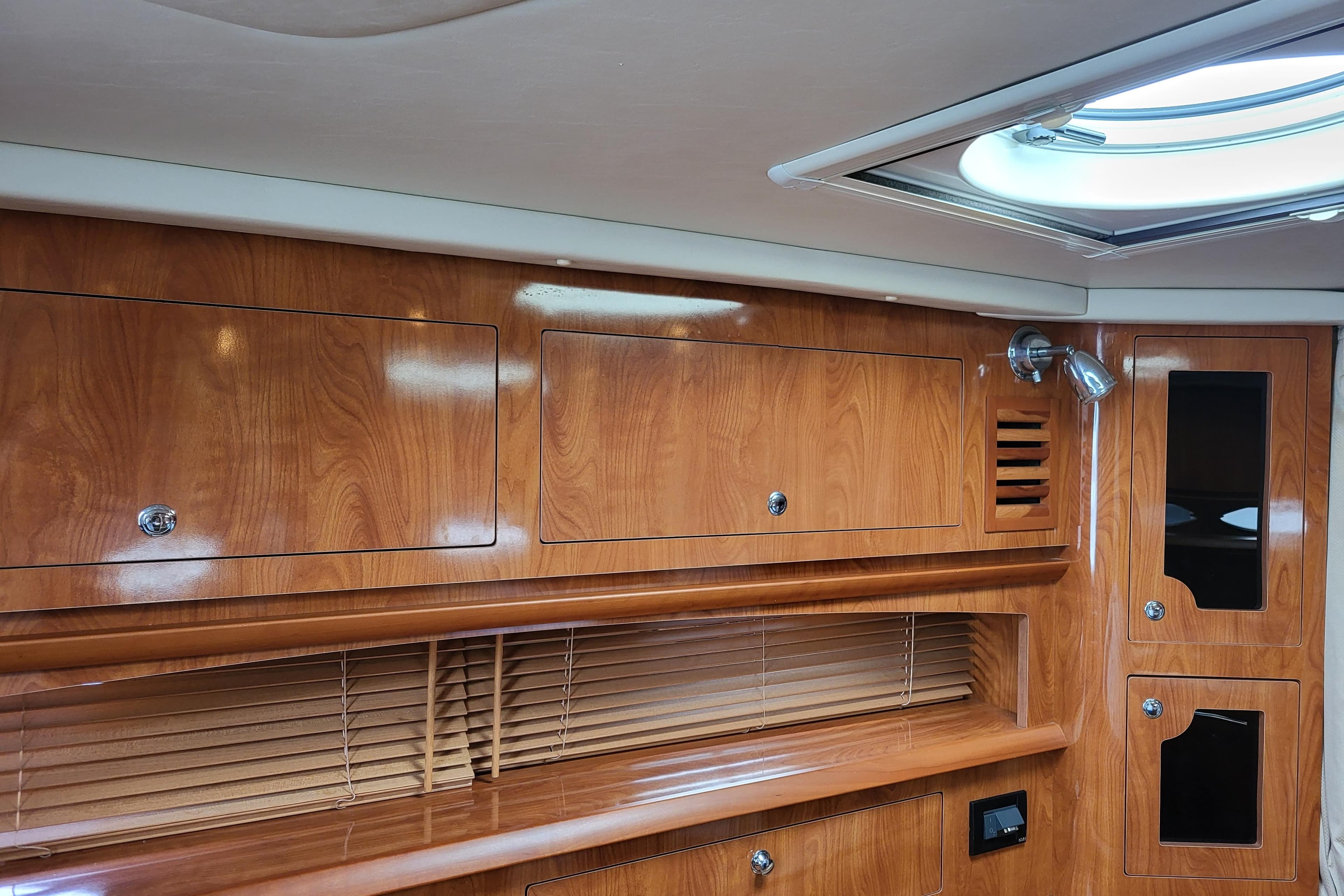 Luxurious wood interior of 2006 Four Winns 348 Vista yacht cabin with skylight.