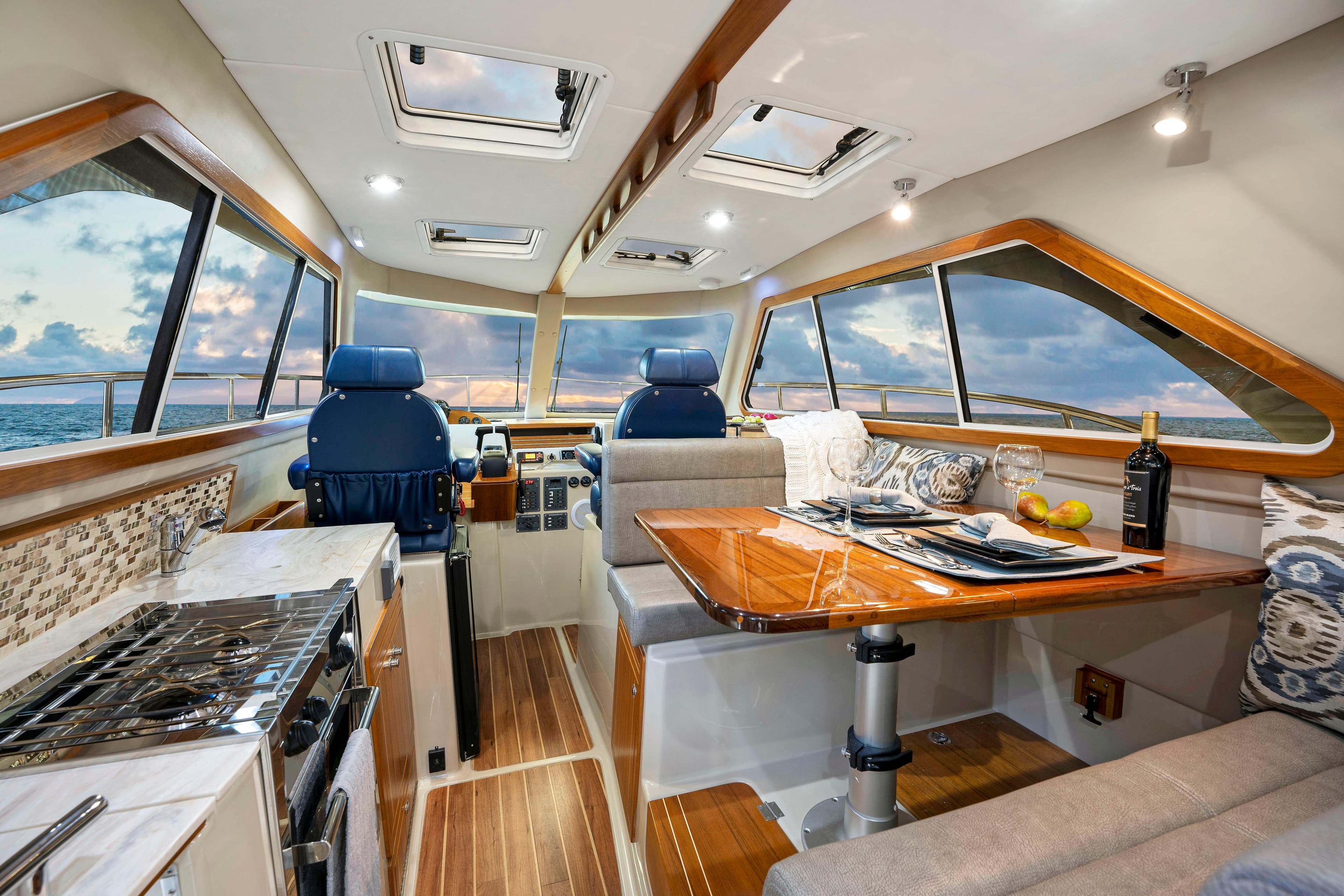 Luxurious interior of 2026 Aspen C100 yacht with dining area and ocean view.
