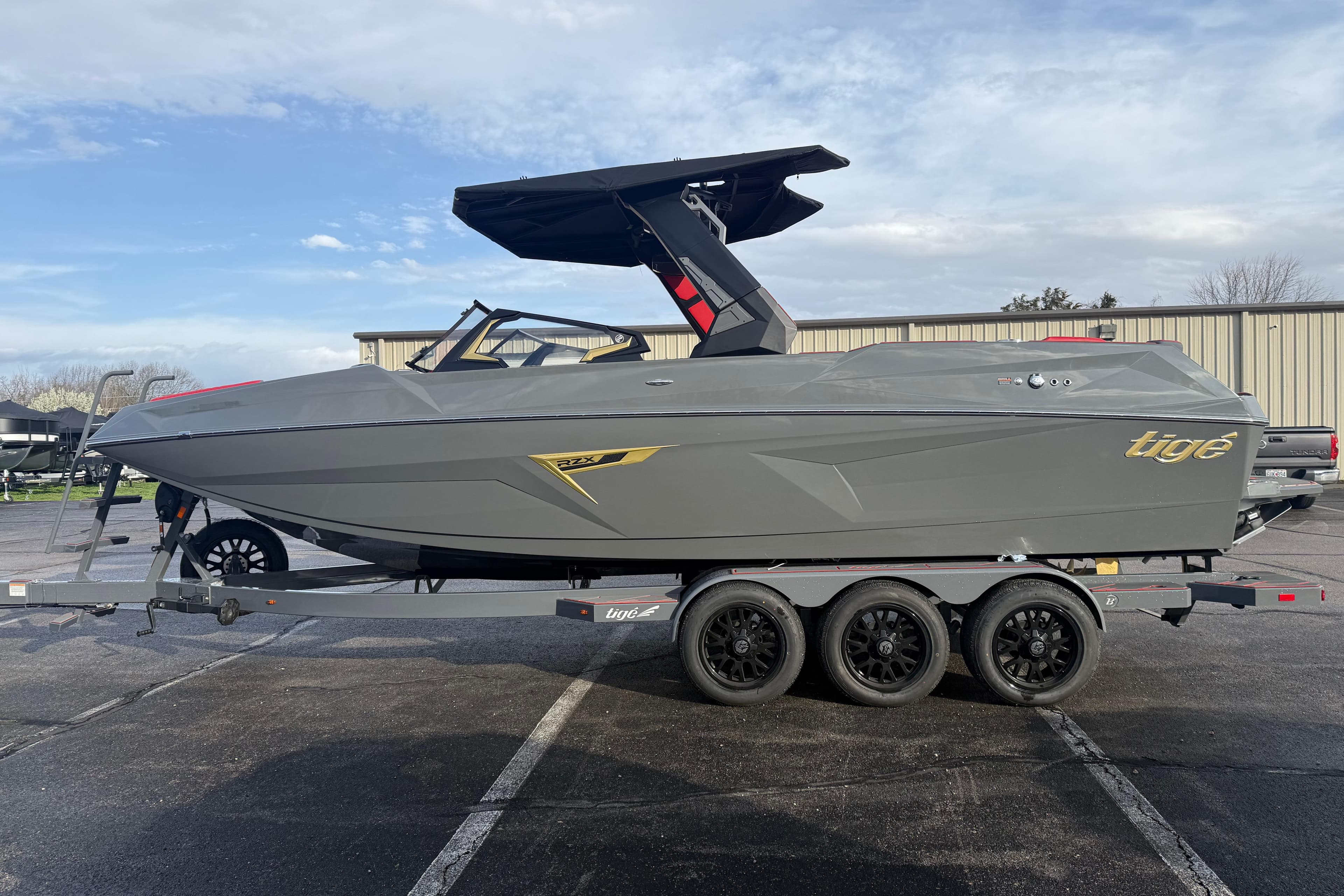 2026 Tigé 24RZX boat on trailer, sleek gray design, parked outdoors.
