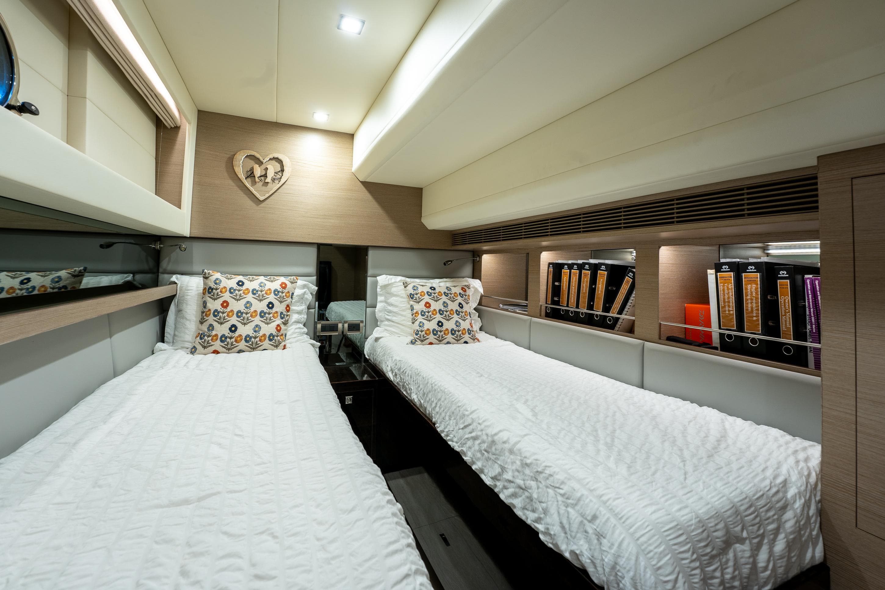 Luxurious twin cabin in 2020 Horizon PC60 yacht with modern decor and cozy bedding.