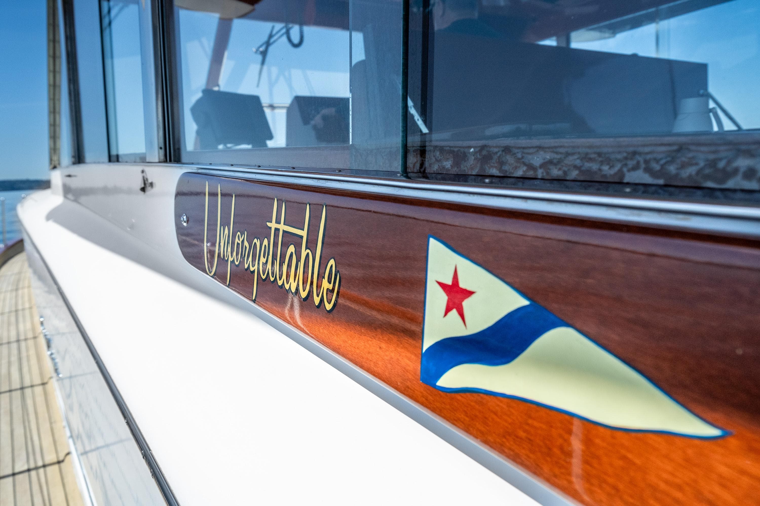 1965 Chris-Craft 57 Constellation yacht with "Unforgettable" nameplate and nautical flag.