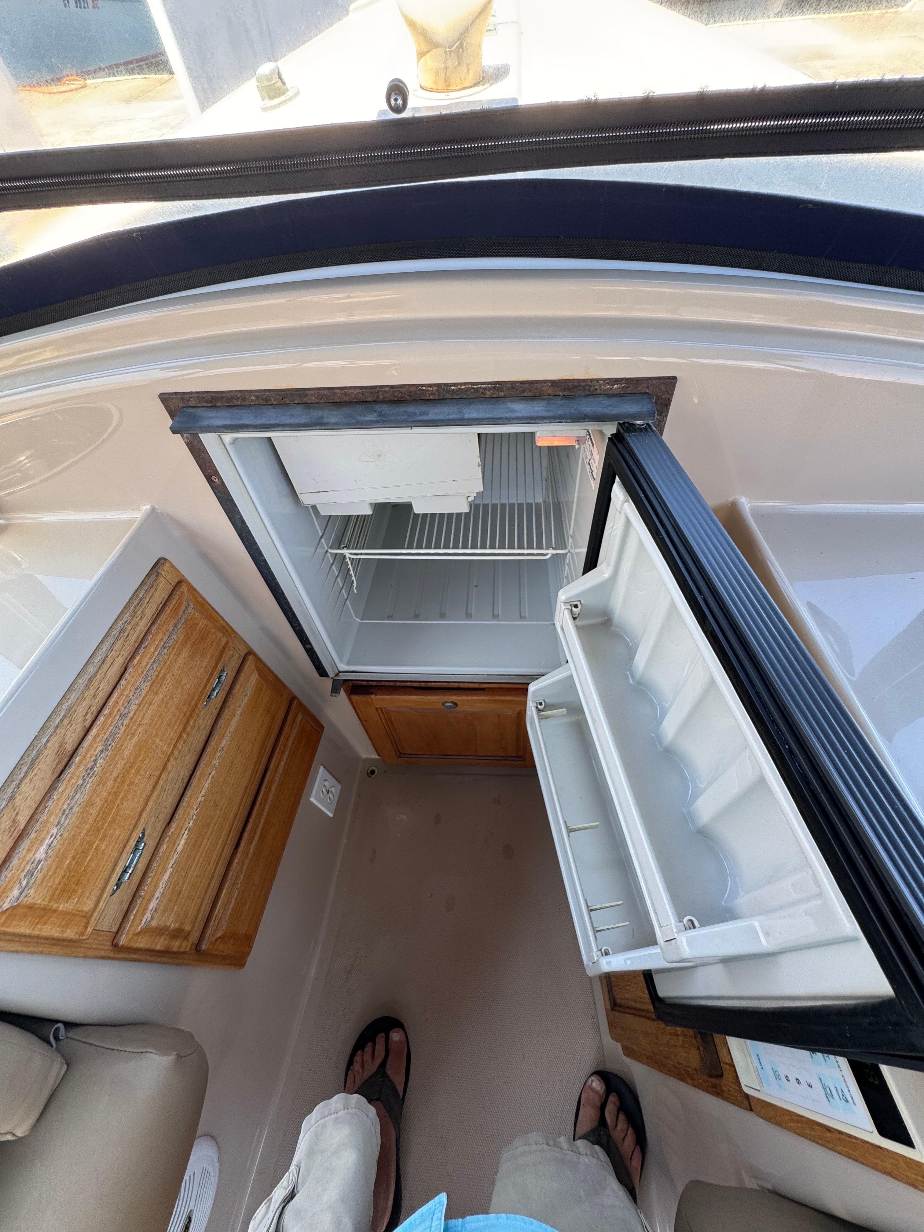 Open fridge inside a 2004 Duffy NEWPORTER boat, with wooden cabinets nearby.