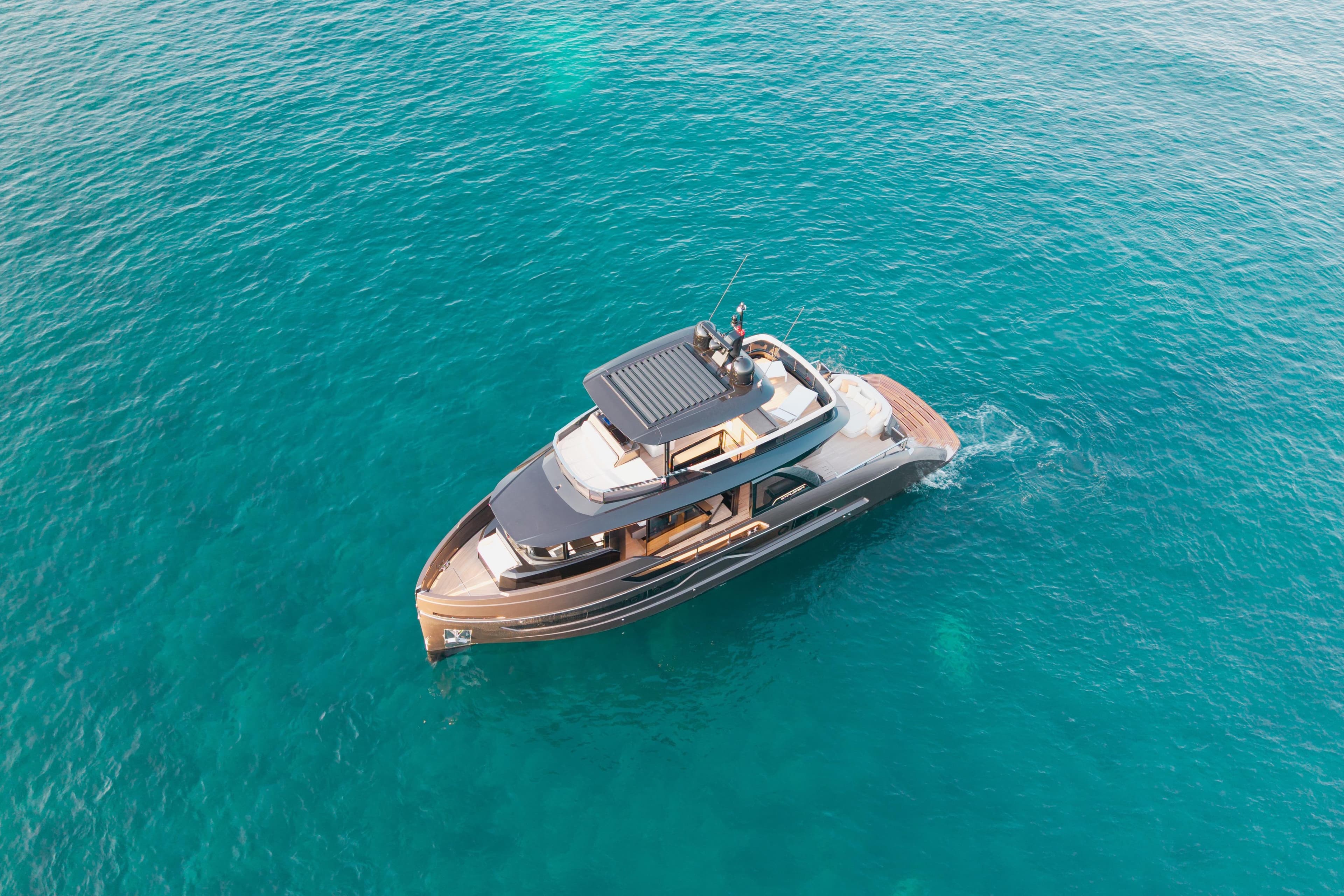 Aerial view of 2025 Explorer 62 yacht cruising in clear blue ocean waters.