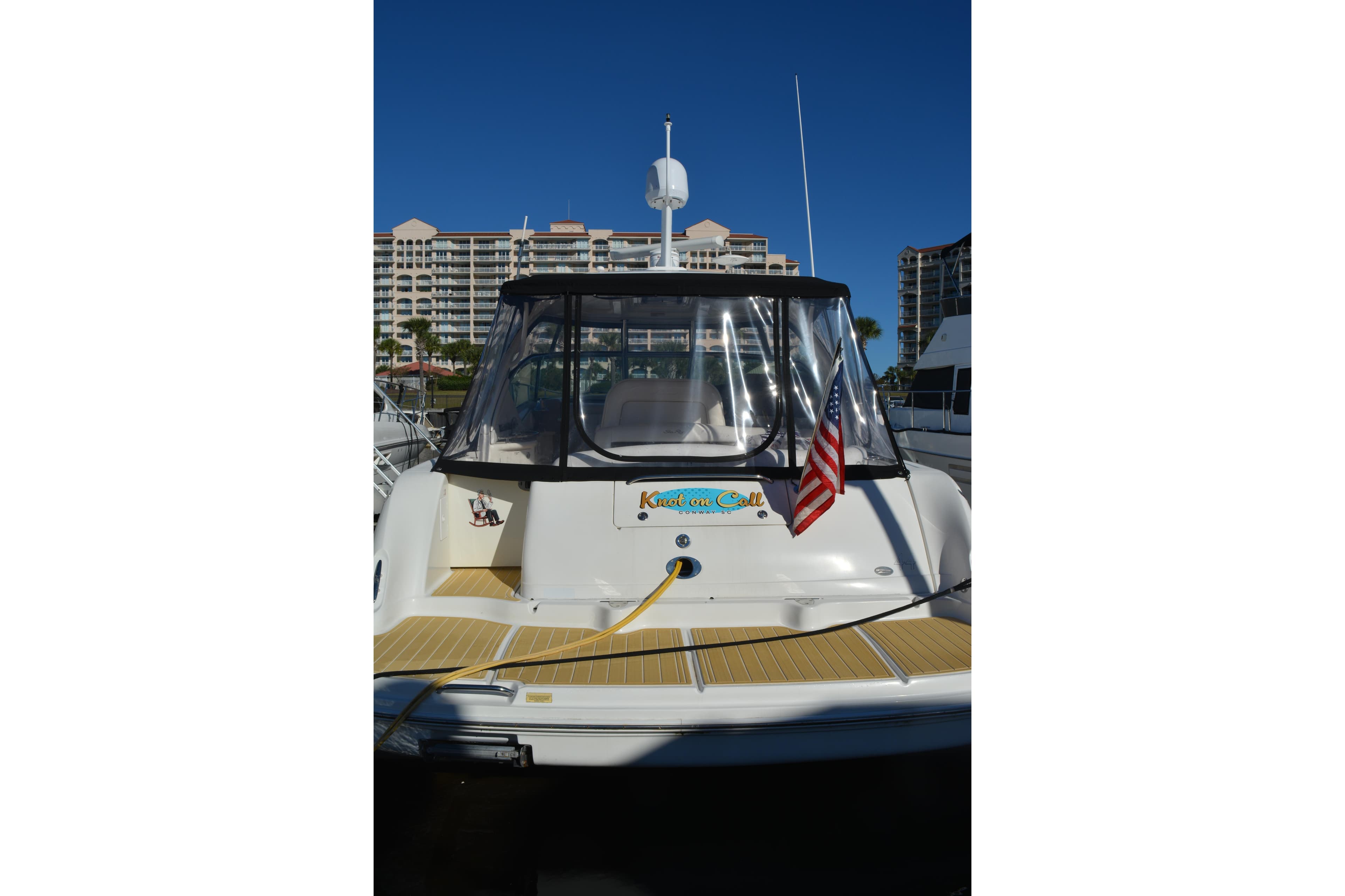 2007 Sea Ray 44 Sundancer yacht docked, featuring American flag and clear canopy.