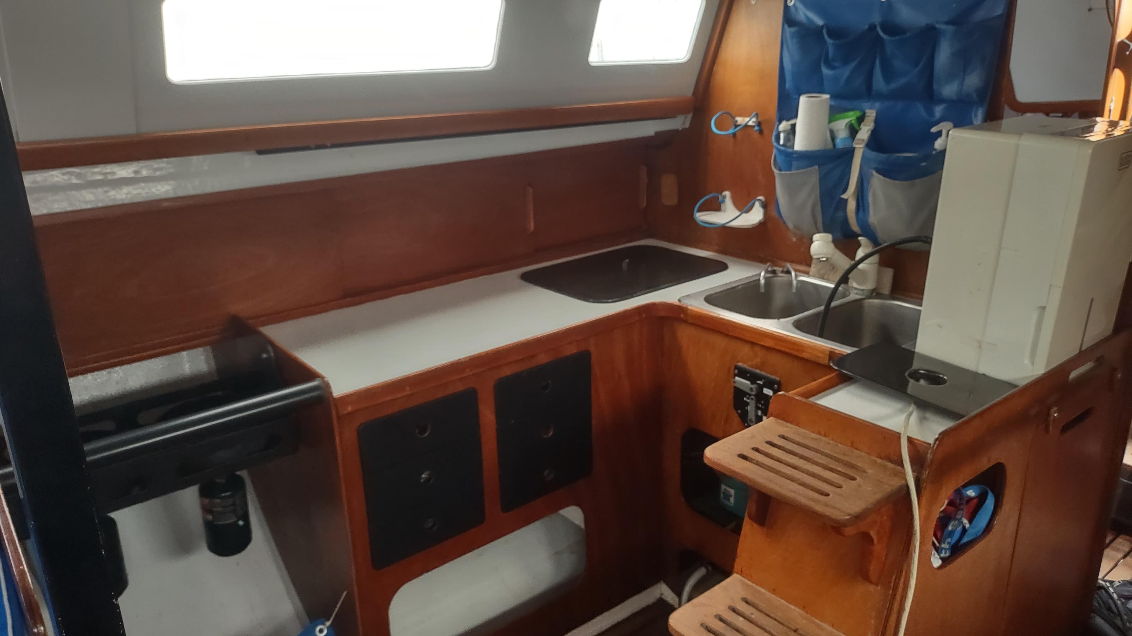 Interior of 1980 Santa Cruz SC 50 sailboat kitchen with wooden cabinetry and sink.