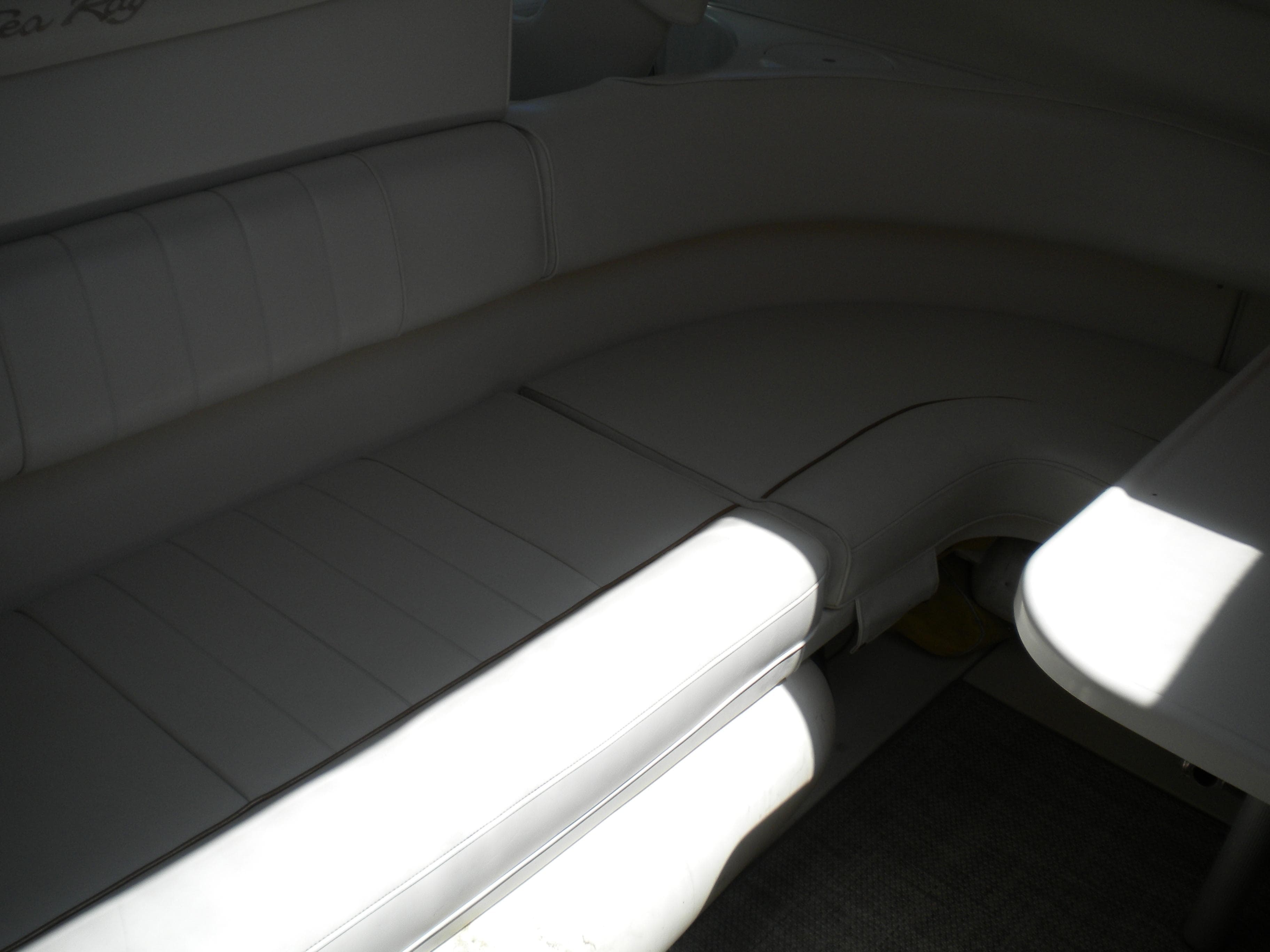 Interior seating of 1997 Sea Ray 400 Sundancer yacht, featuring white upholstery.