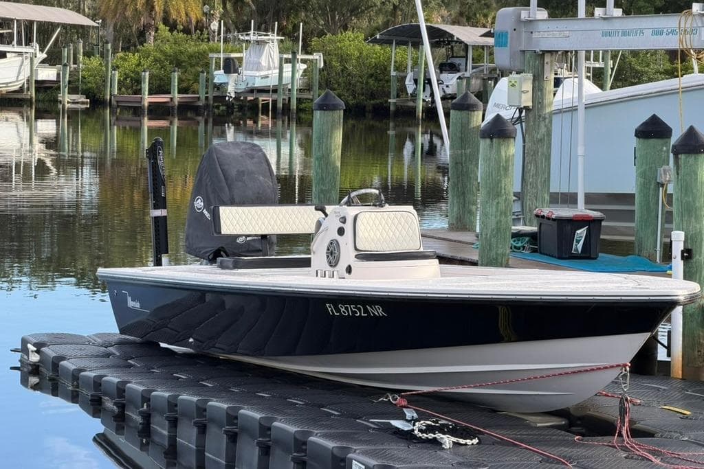 2008 Maverick 21 Master Angler boat docked at a marina with lush greenery.