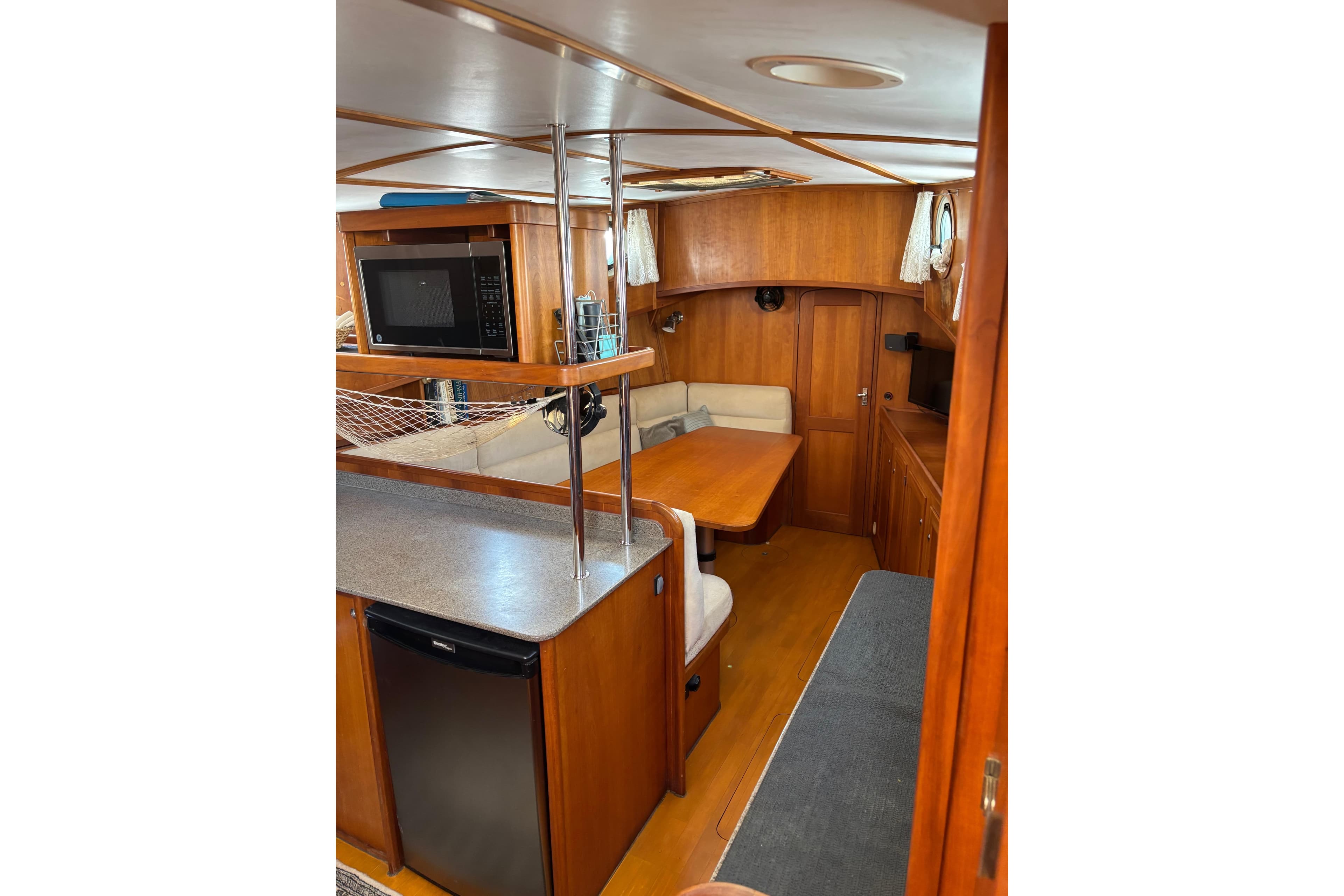 Interior of 1999 Diesel Duck Trawler with kitchen and dining area, featuring wood finish.