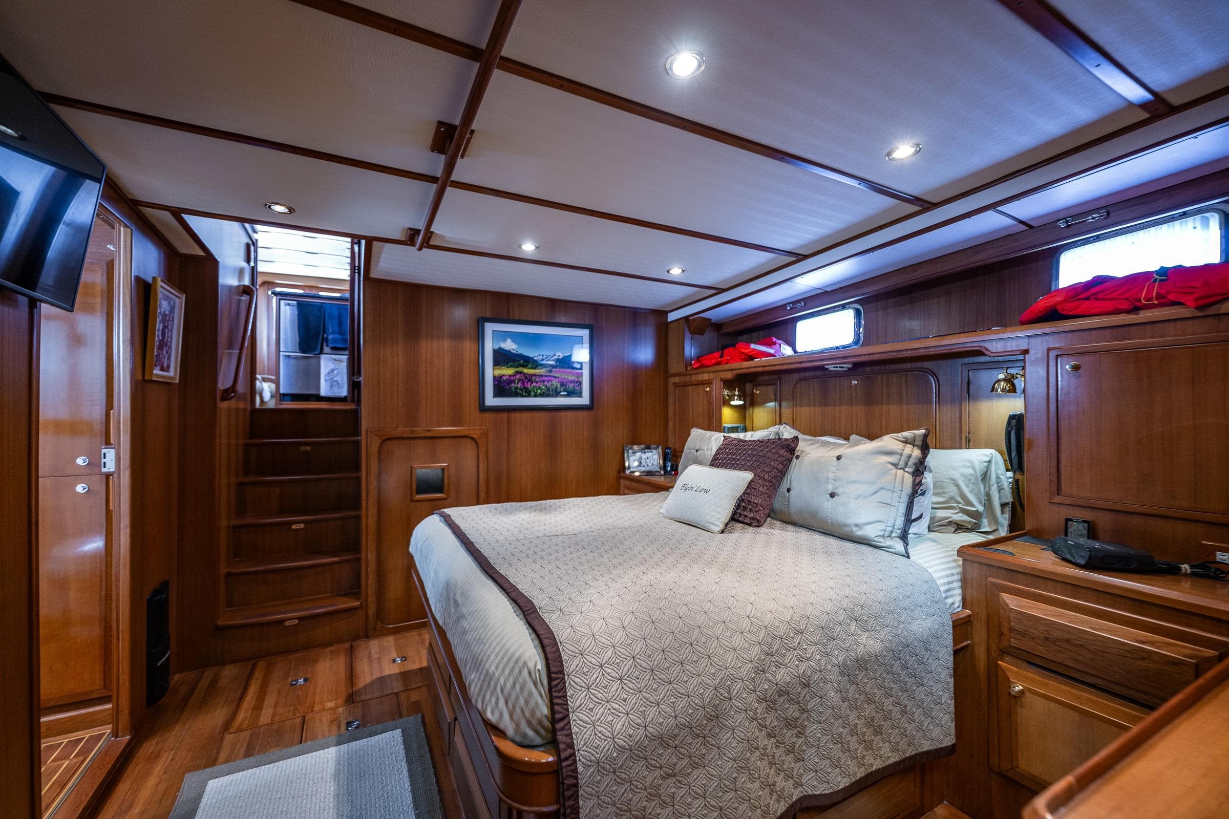 Luxurious 2007 DeFever 56 yacht bedroom with elegant wood paneling and cozy bedding.