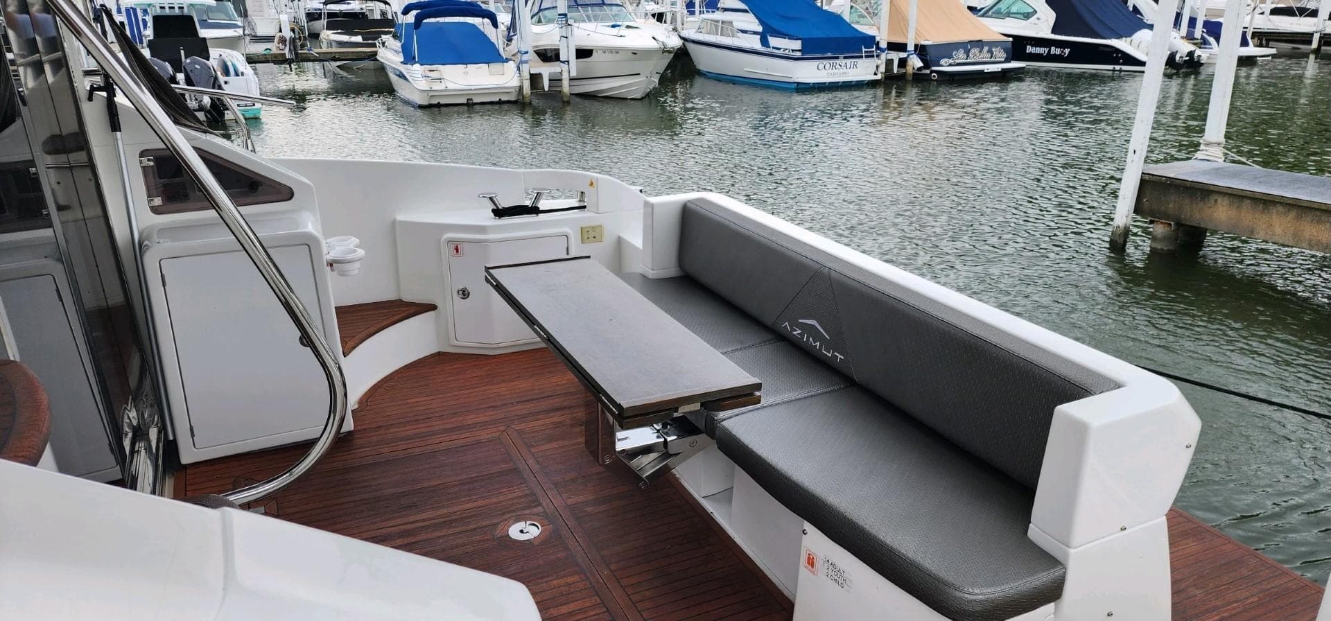 2013 Azimut 45 Flybridge yacht with outdoor seating and table, docked at marina.