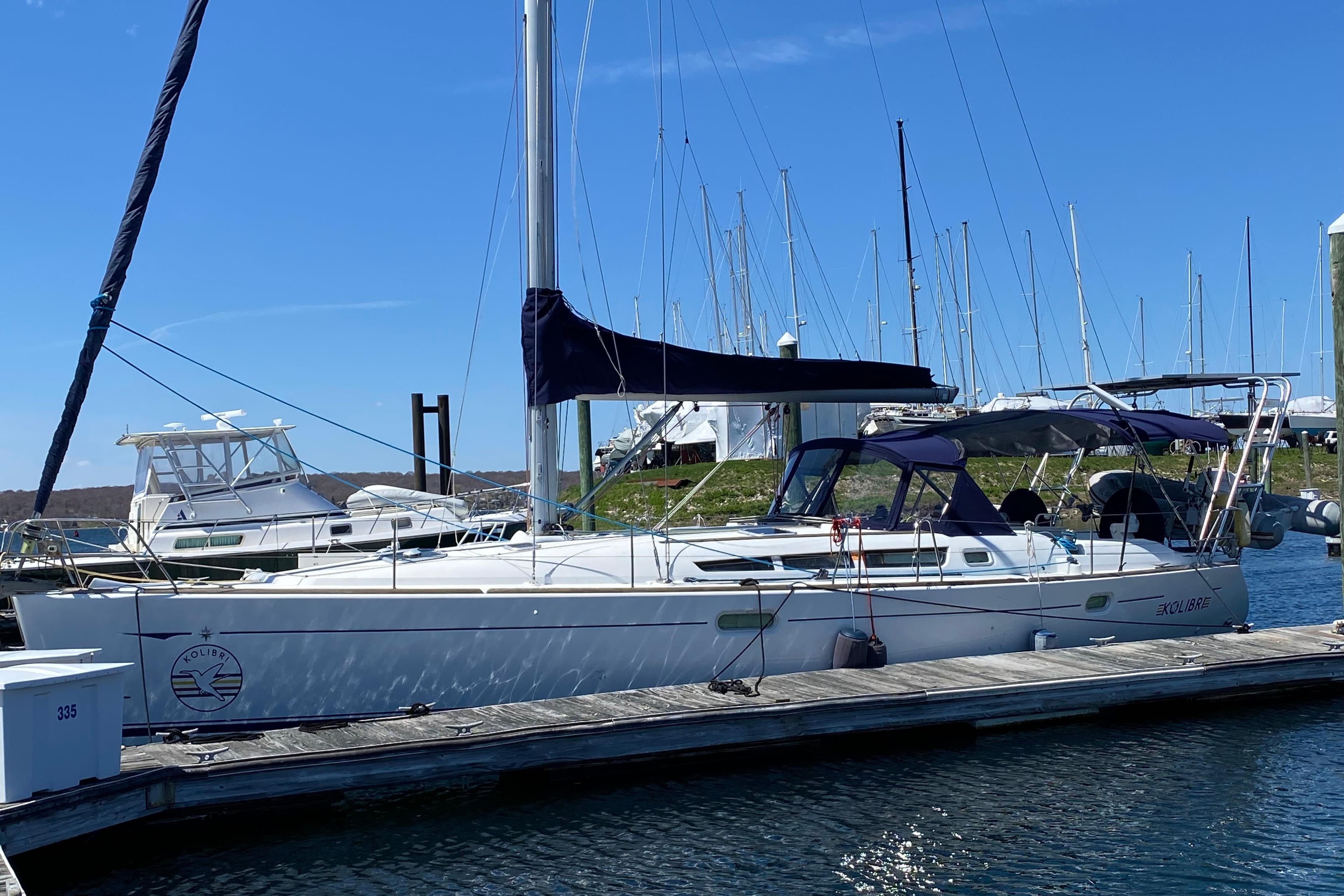 2006 Jeanneau Sun Odyssey 45 sailboat docked at marina under clear blue sky.
