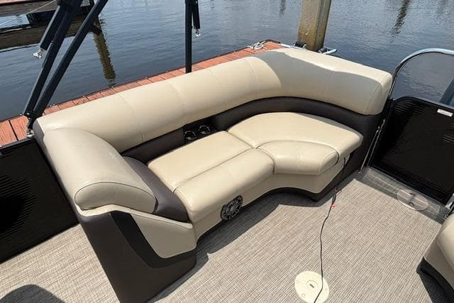 2022 Manitou 25 Oasis RF boat interior with beige seating and carpeted flooring.