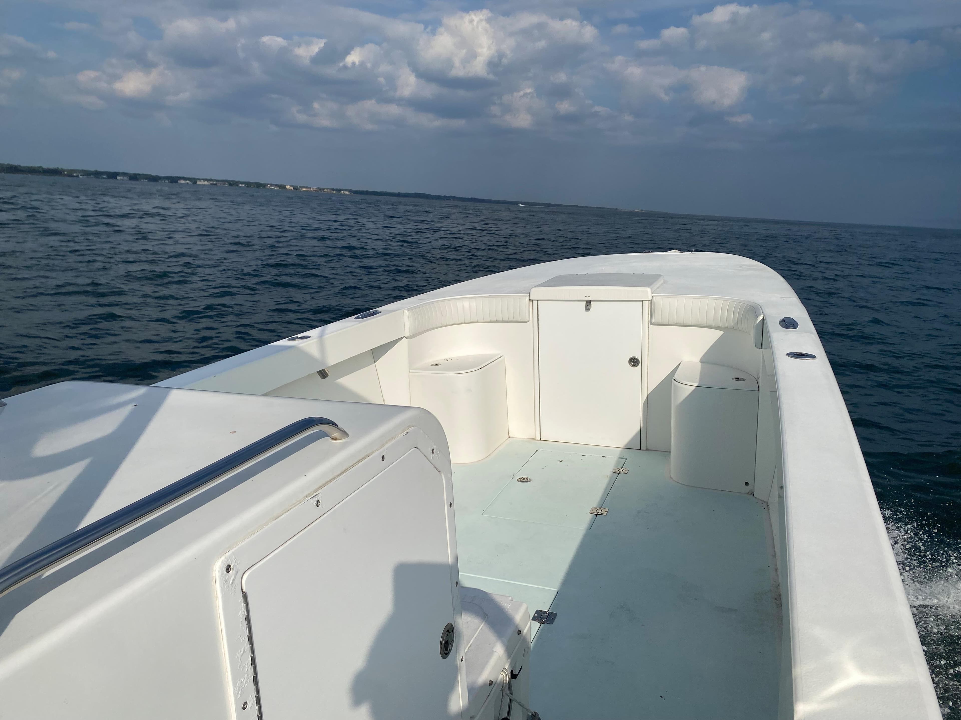 2006 Kryptonite 41 CC boat on open water under a partly cloudy sky.