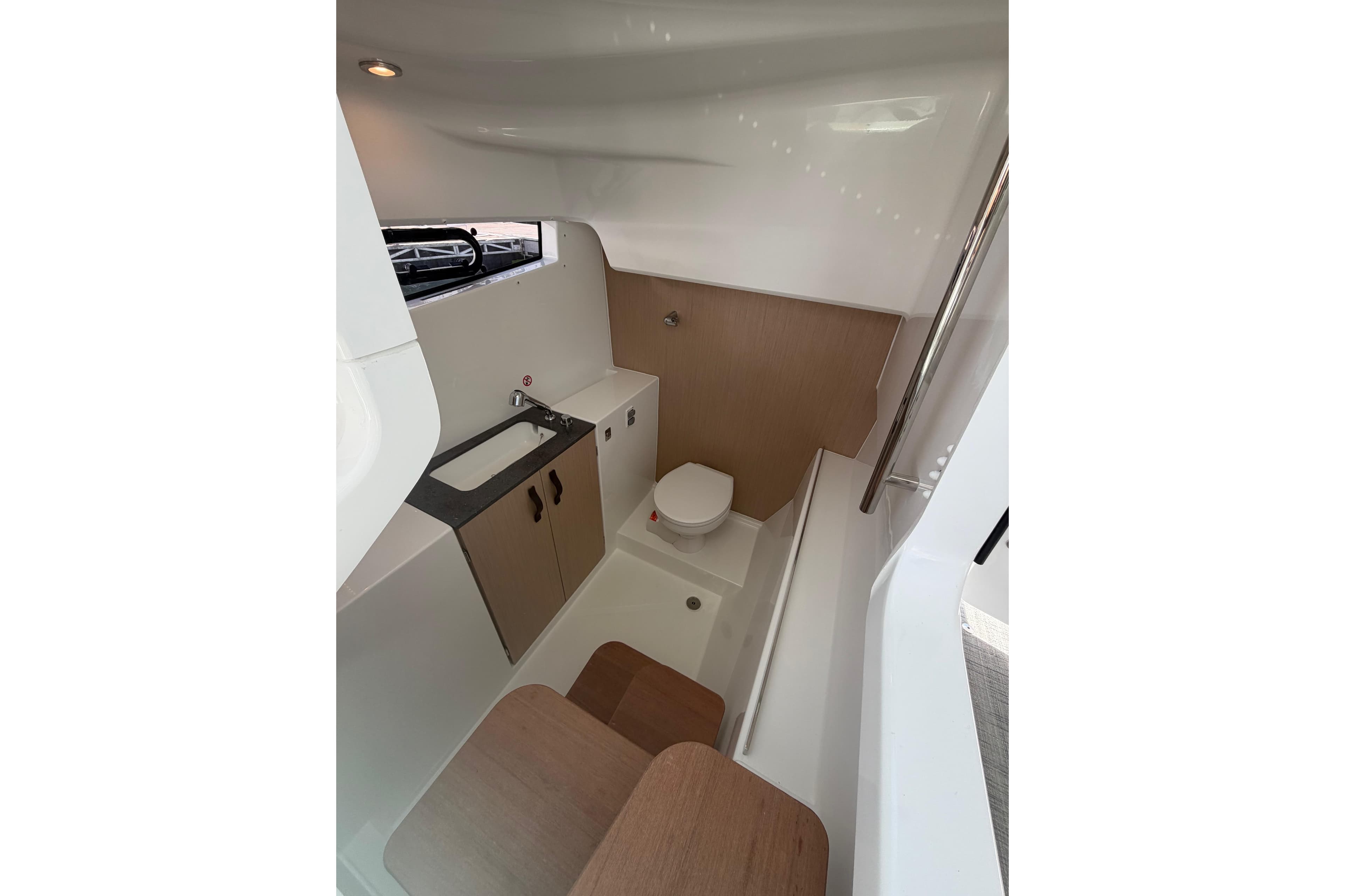 Modern bathroom interior of 2026 Jeanneau TH33 boat, featuring sink, toilet, and storage.