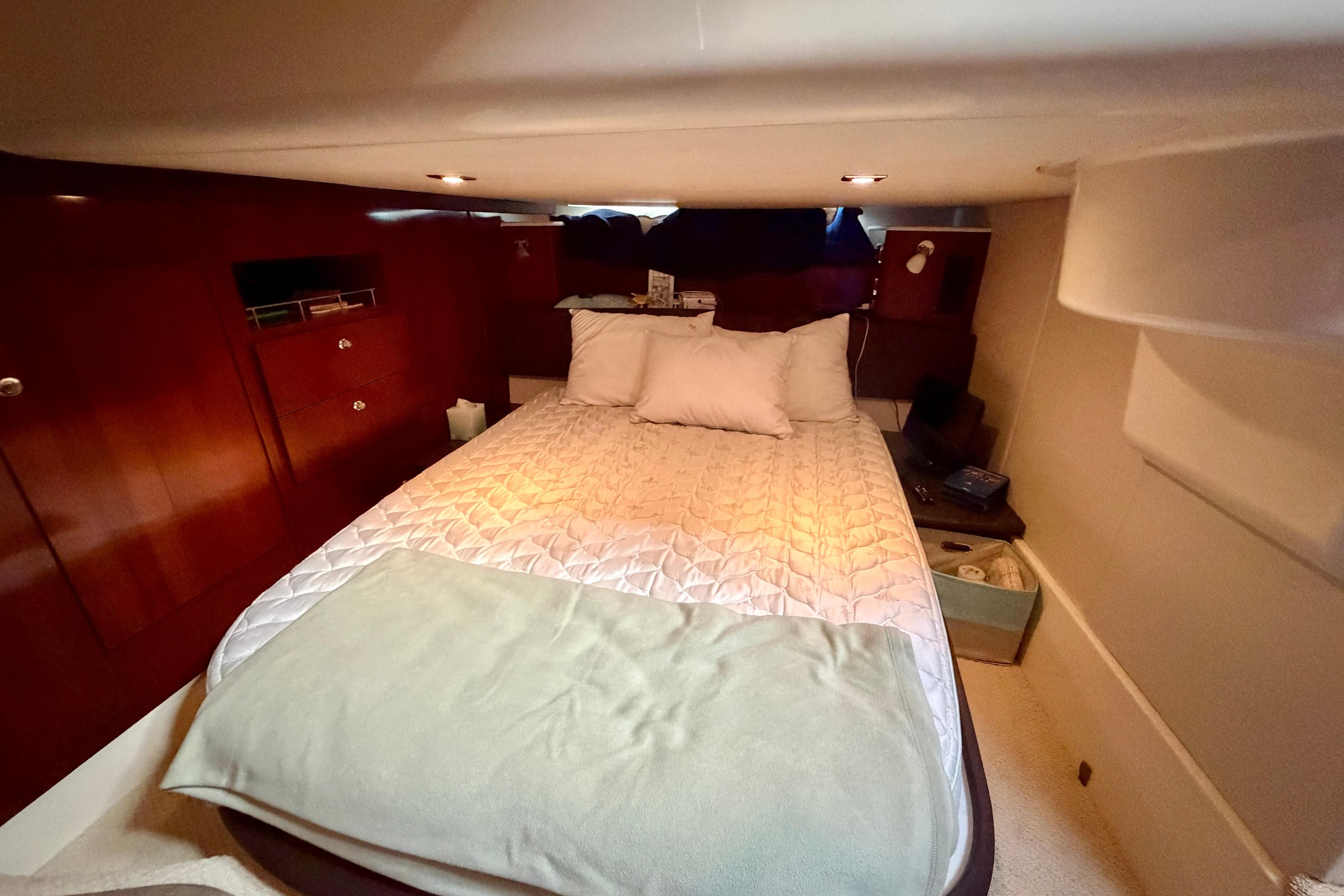Luxurious bedroom interior of 2011 Meridian 441 Sedan yacht with cozy bedding.