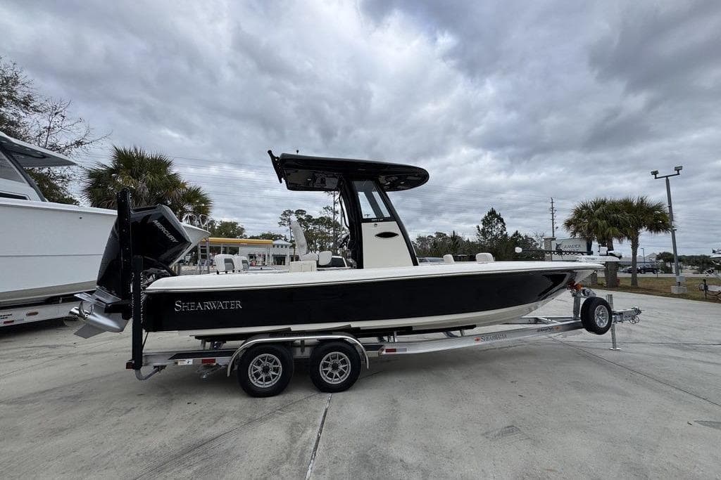 2026 ShearWater 260 Carolina Flare boat on trailer, parked outdoors under cloudy sky.