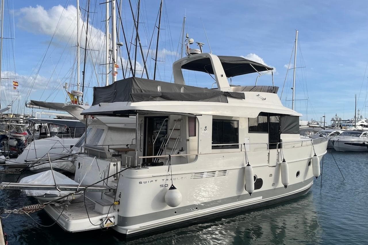 2021 Beneteau Swift Trawler 50 docked at marina, surrounded by other boats.