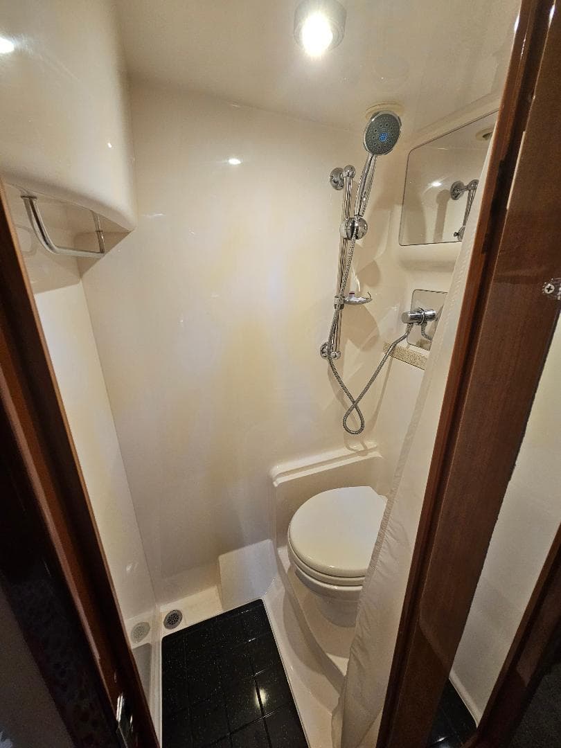 Compact bathroom in 2007 Regal Commodore 4460 yacht with shower and toilet.