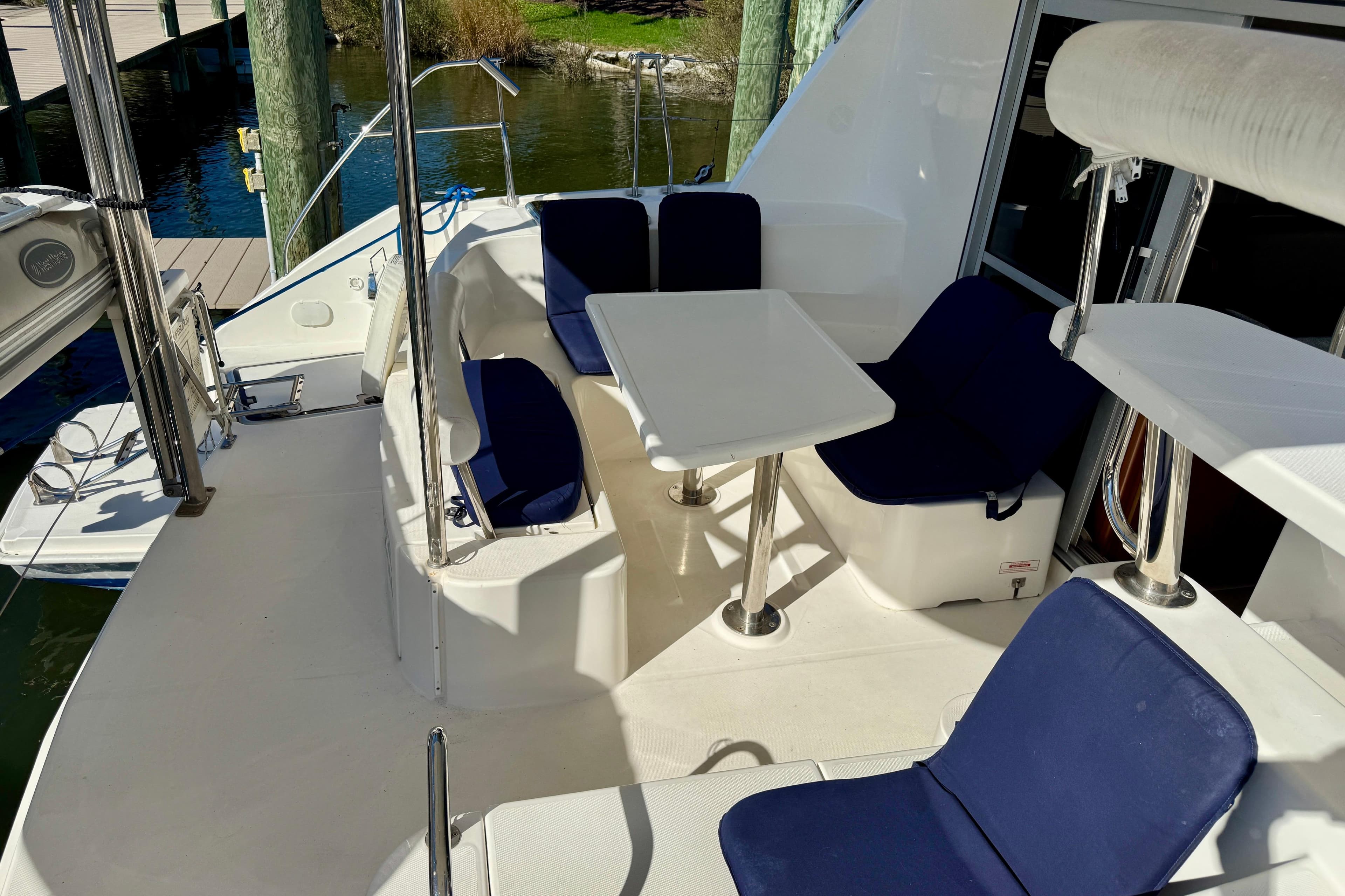 2010 Leopard 38 yacht deck with blue cushioned seating and table.