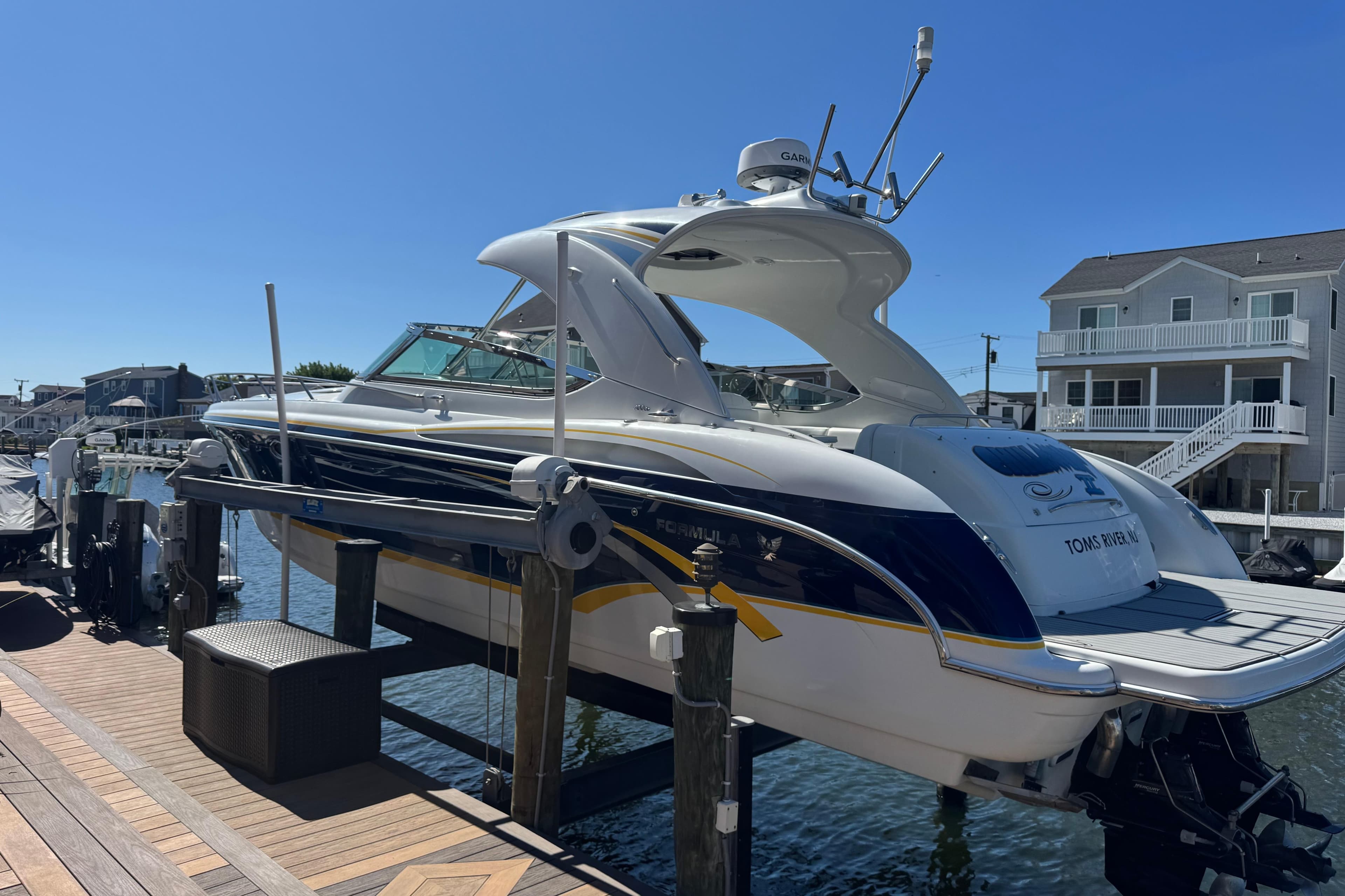 2006 Formula 400 Super Sport boat docked at a marina under clear blue skies.
