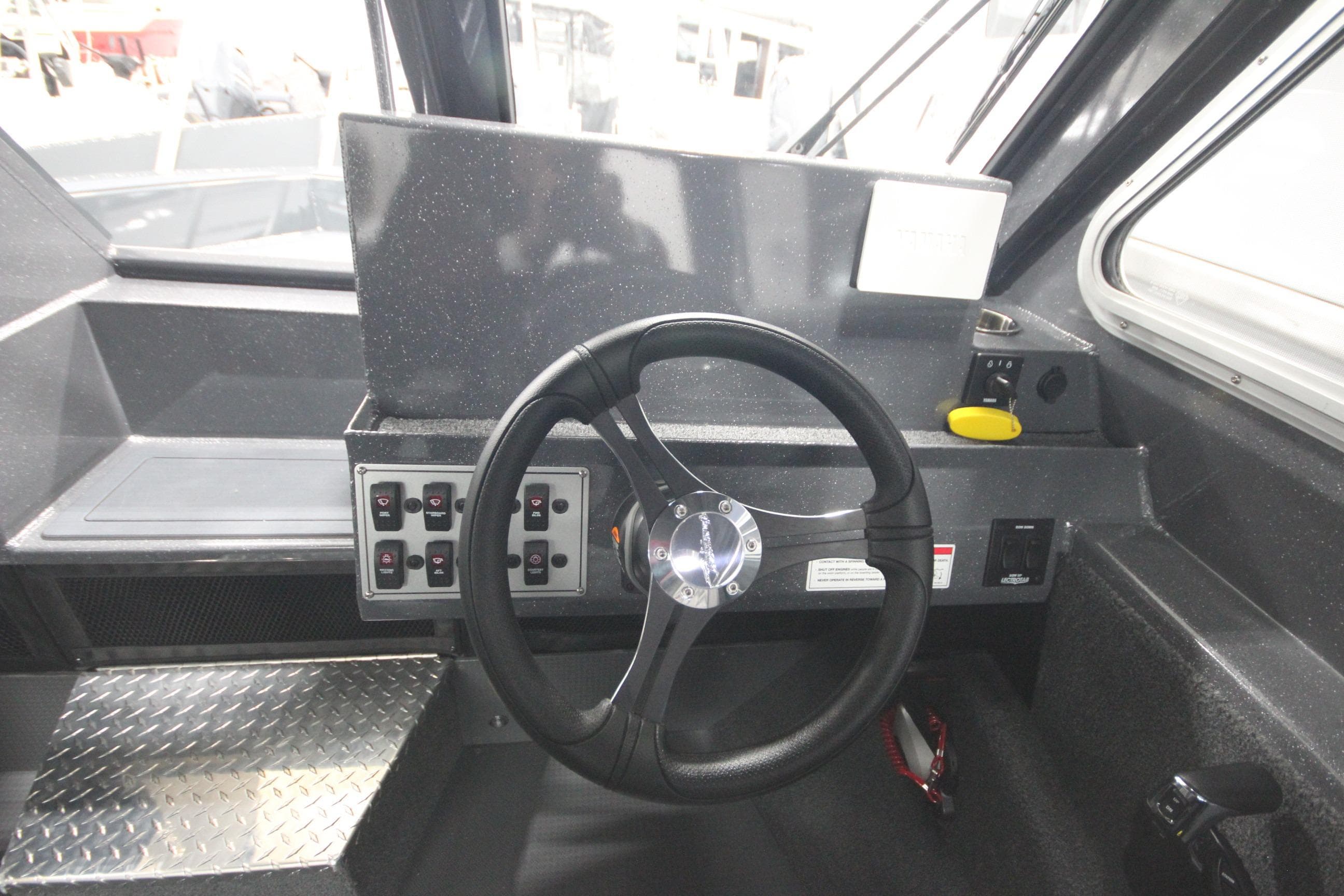 2026 Weldcraft 240 Ocean King F300XCB boat helm with steering wheel and control panel.